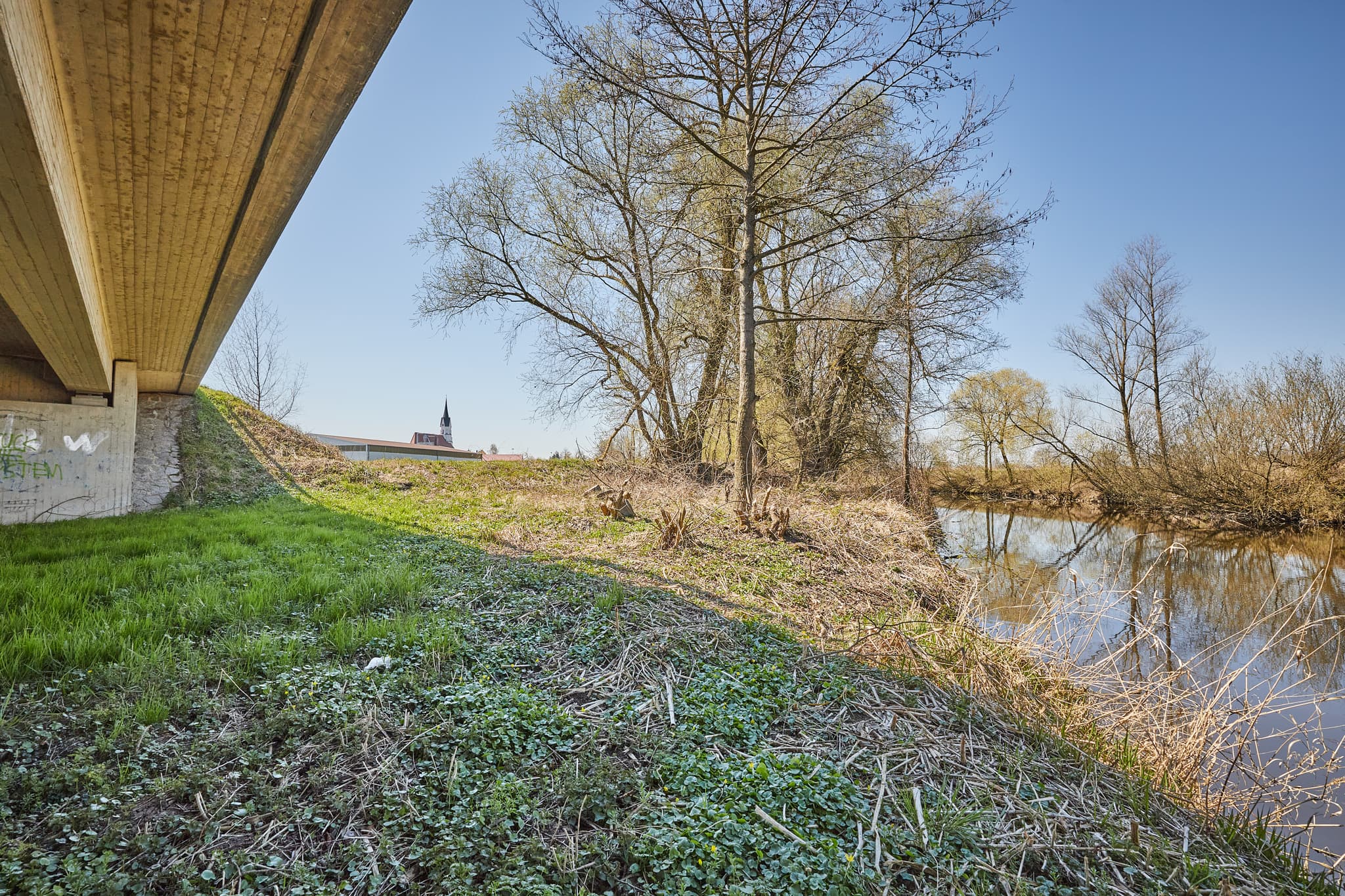 Blick unter die Rott Brücke in Unterdietfurt,  Rottal-Inn, Niederbayern, Deutschland. Die Landschaft des Holzlandes mit Flussufer und Vegetation.