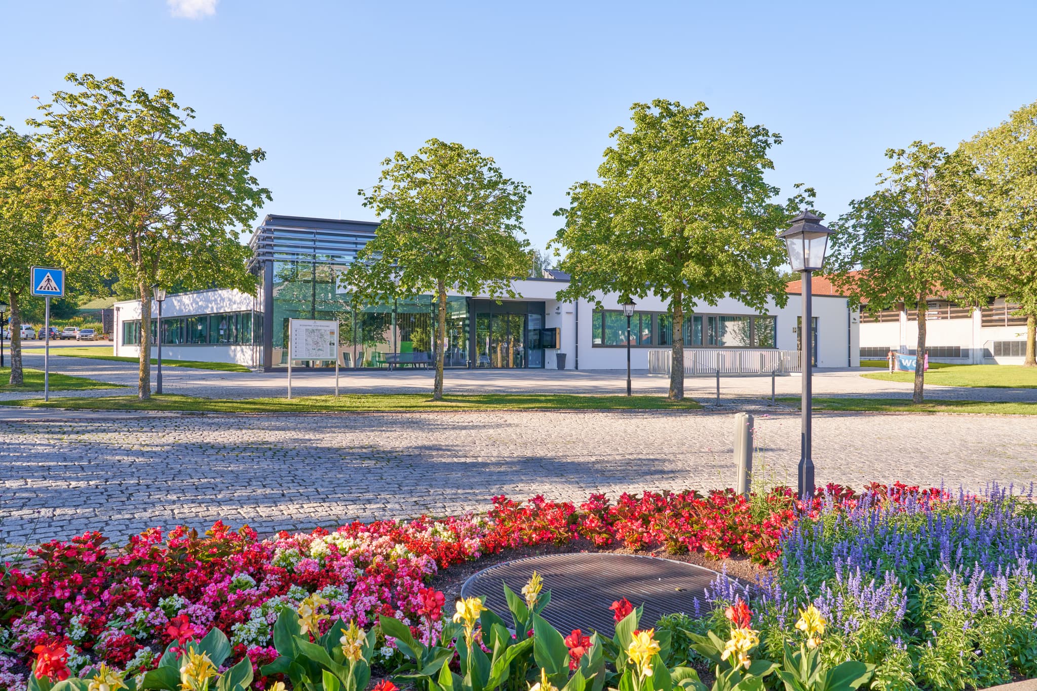 Bad Griesbach in Passau, Niederbayern, Deutschland. Bunte Blumenbeete und Bäume schmücken den Vorplatz dieser Kuranlage in der Donau-Wald Region.