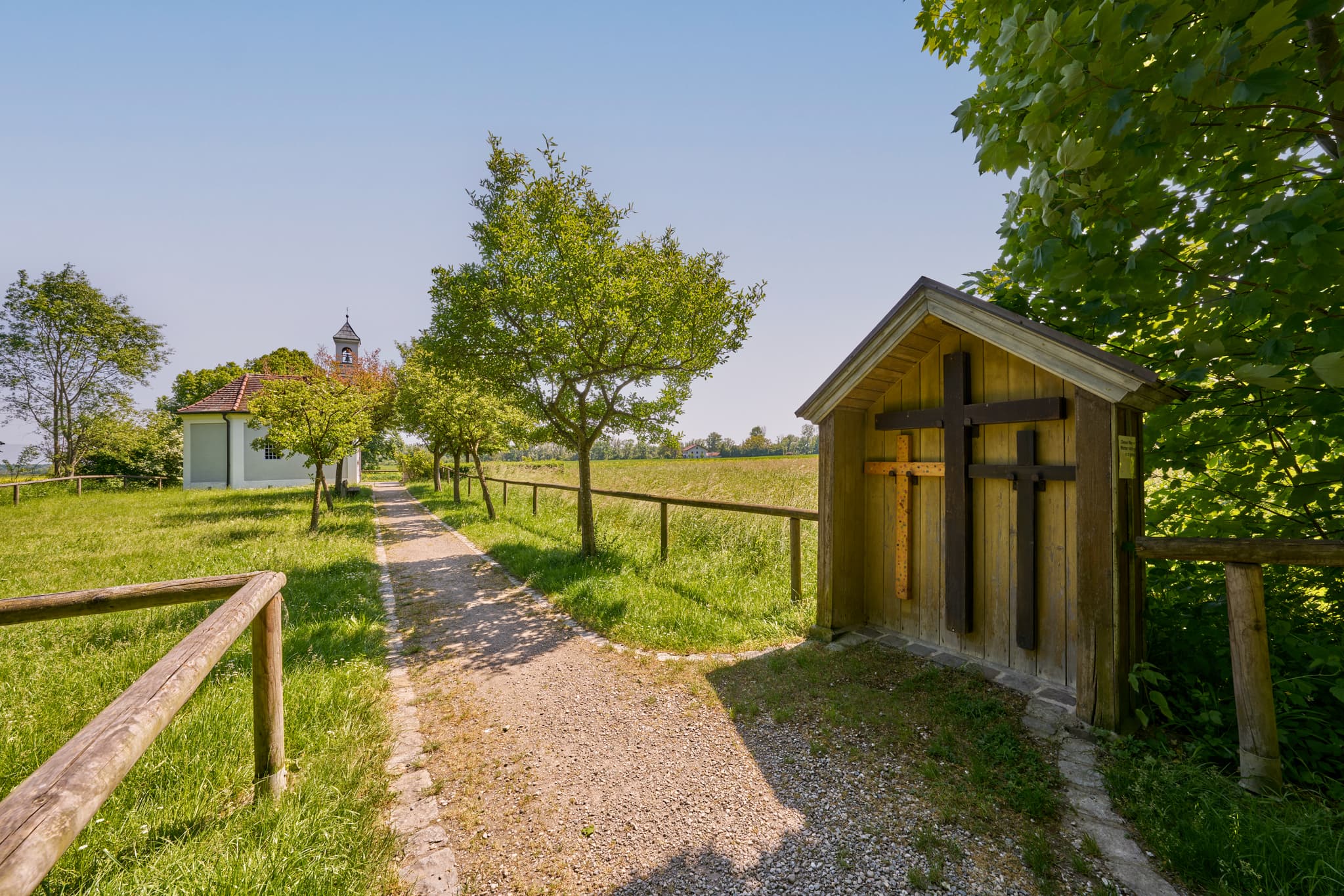 Kapelle in Ecksberg Altmühldorf, Mühldorf am Inn, Oberbayern, Deutschland. Ein Pfad durch Wiesen führt zum Bauwerk mit Wegkreuz. Idylle der Inn-Salzach Region.