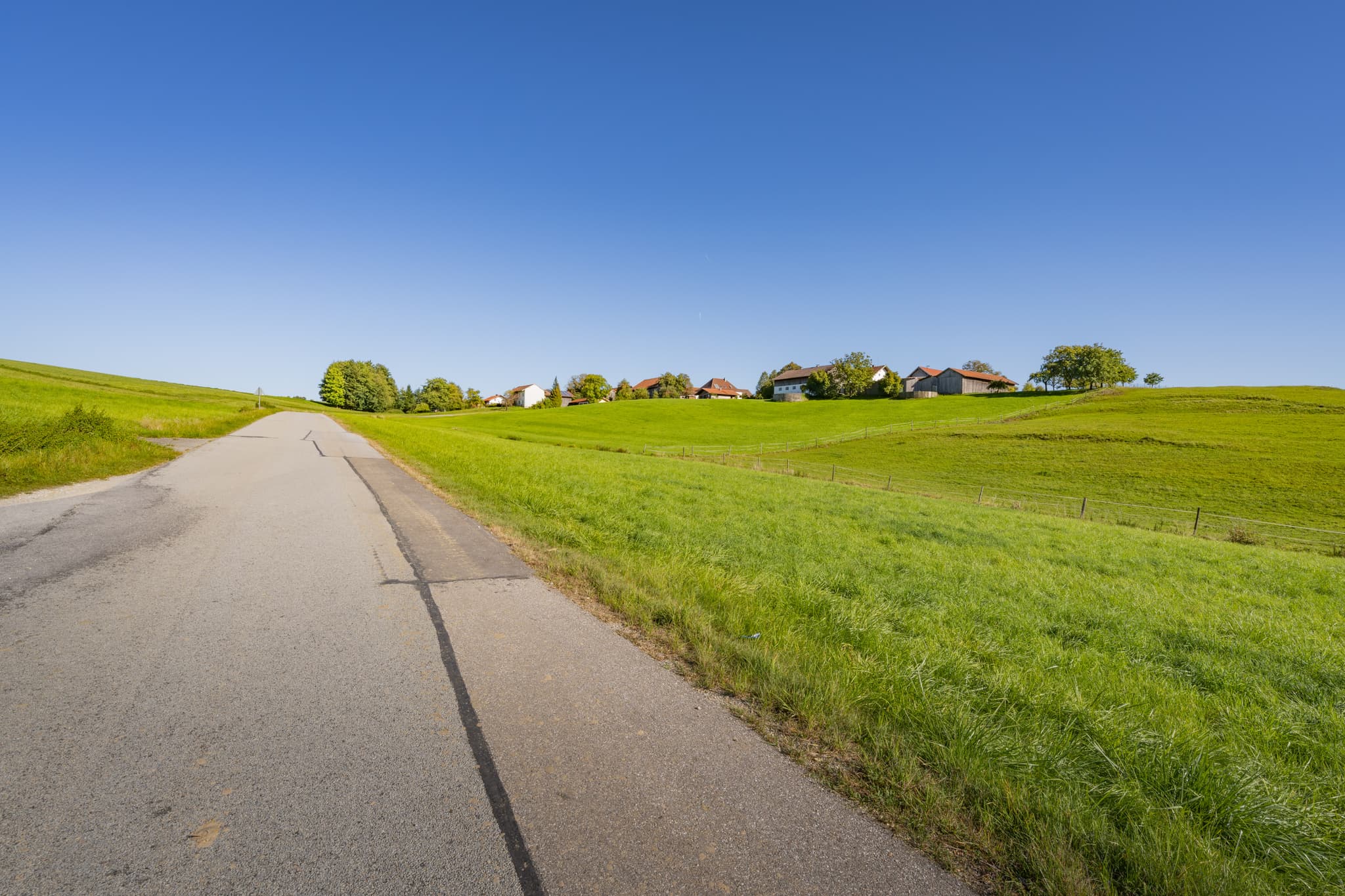 Landschaftsblick in Lapperding, Johanniskirchen, Rottal-Inn, Niederbayern, Deutschland. Grüne Wiesen, Straße und Häuser prägen die Szenerie der Holzland Region.