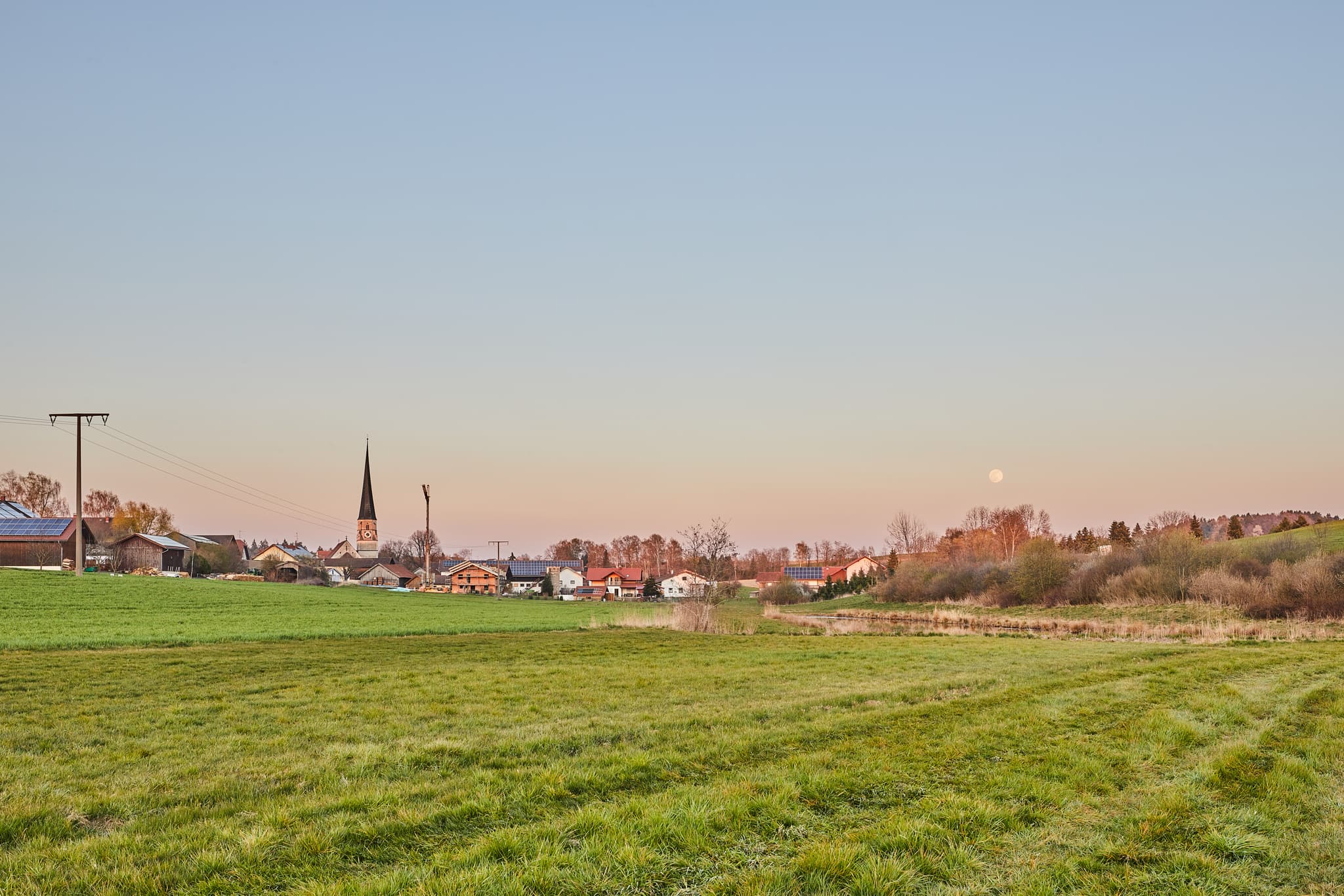 Rogglfing, Ortsteil Wurmannsquick, Landkreis Rottal-Inn, Niederbayern. Ländliche Landschaft im Holzland, Deutschland, mit Feldern, Bebauung und Kirchturm.