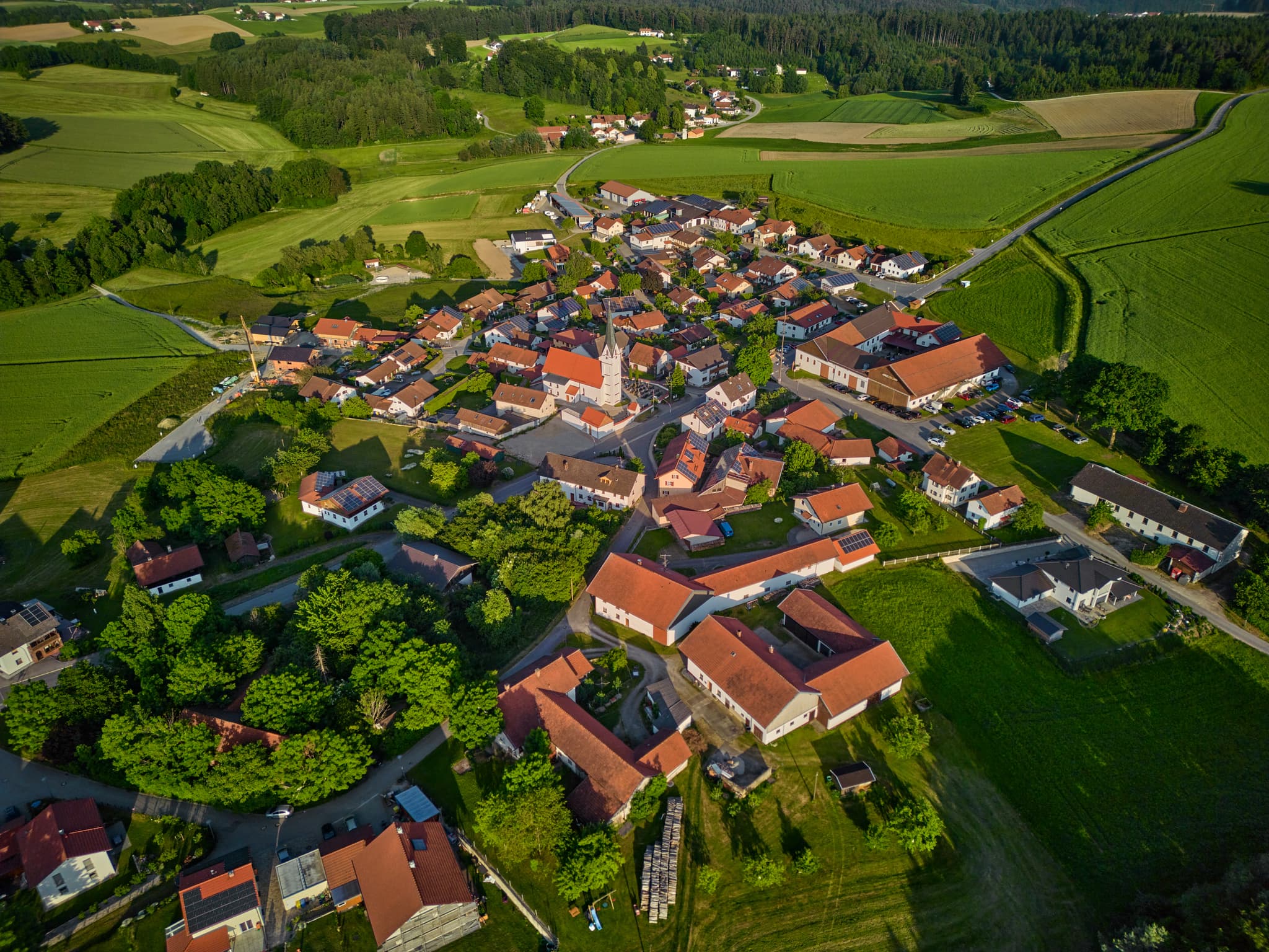 Ortsansicht Arbing, Reischach, Landkreis Altötting, Oberbayern. Kirche im Zentrum des Dorfes, umgeben von ländlicher Natur des Holzlandes, Deutschland.