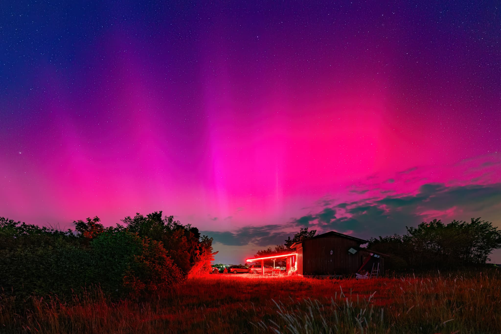 Polarlichter über Sternwarte in Wurmannsquick, Rottal-Inn, Niederbayern. Landschaft im Holzland, Deutschland, zeigt beeindruckende Himmelsphänomen.