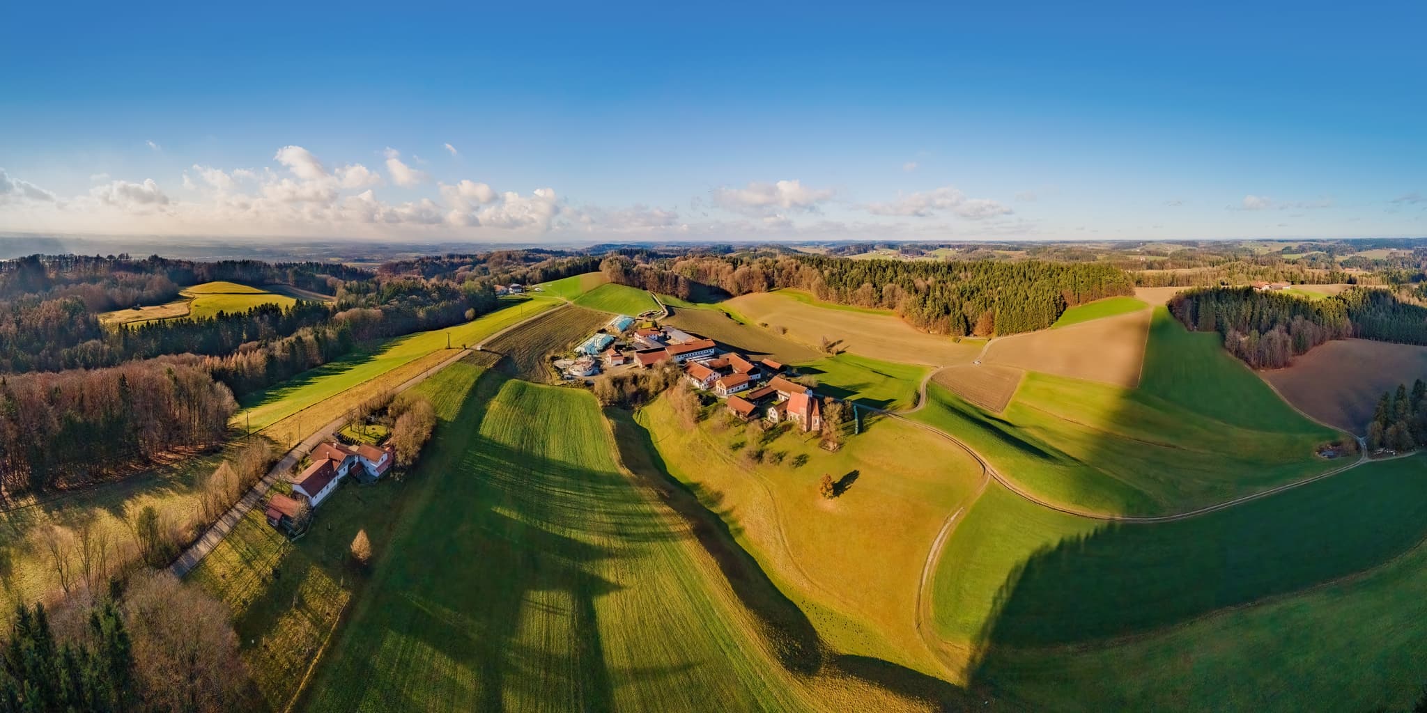 Berg Ortsteil Reischach, Landkreis Altötting, Oberbayern, Deutschland. Die Inn-Salzach Region zeigt Hügel, Felder, Wald und Kirche St. Veit.