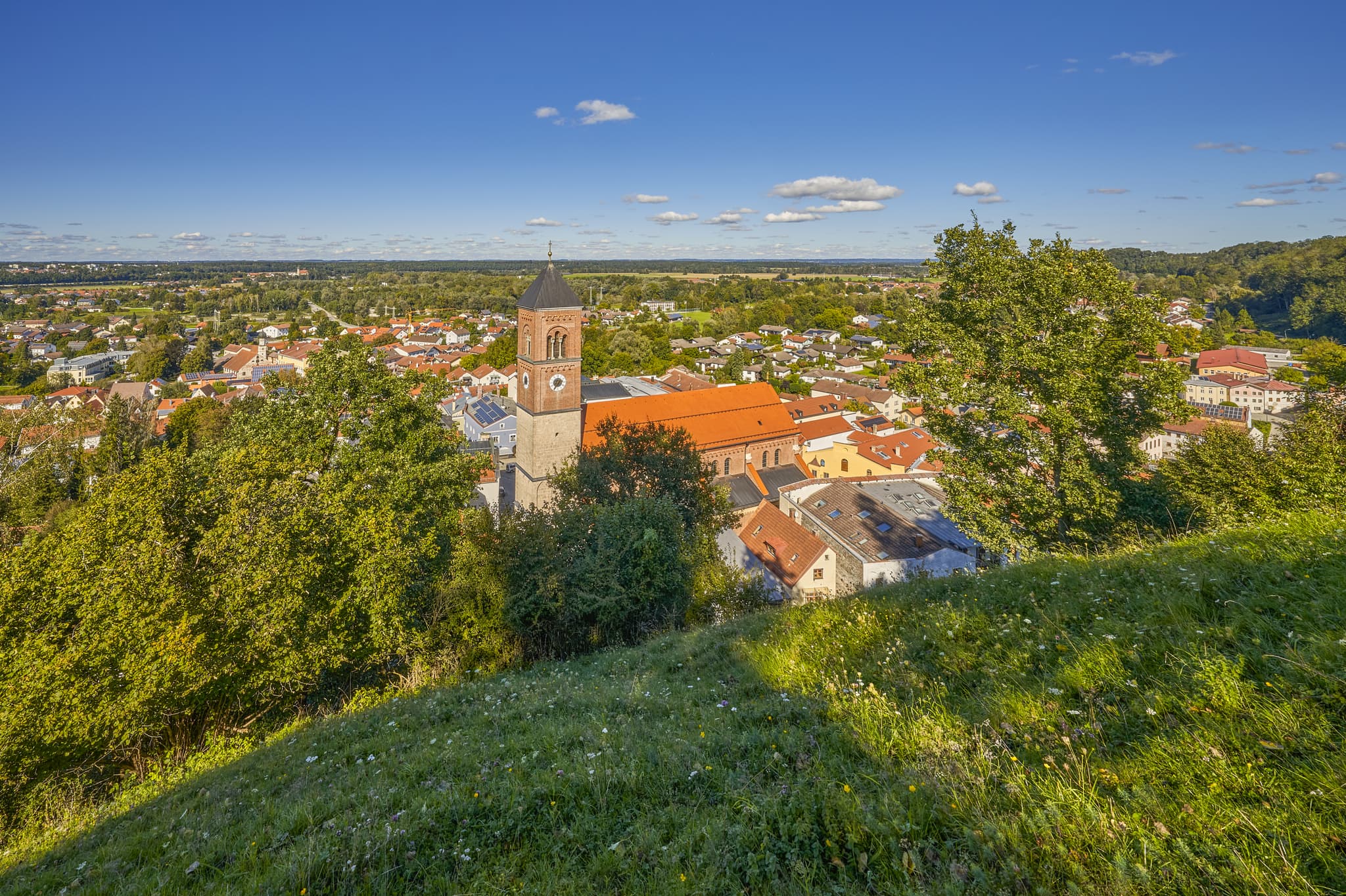 Schlossberg Aussicht auf Kraiburg mit Pfarrkirche St. Bartholomäus, Mühldorf am Inn, Oberbayern, Inn-Salzach, Deutschland. Historisch in grüner Landschaft.