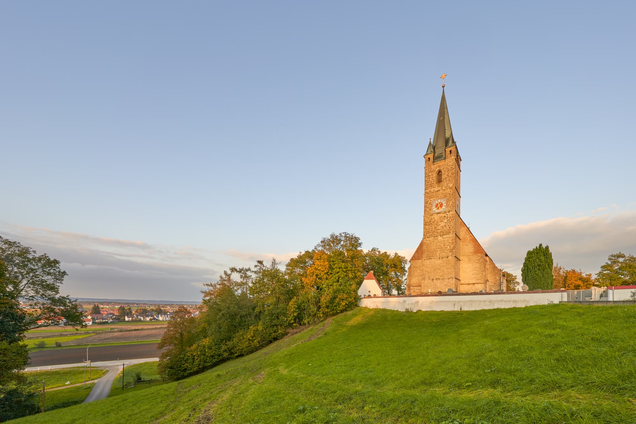 Die Pfarrkirche St. Rupertus in Burgkirchen am Wald, Landkreis Altötting, Oberbayern, thront auf einem Hügel.