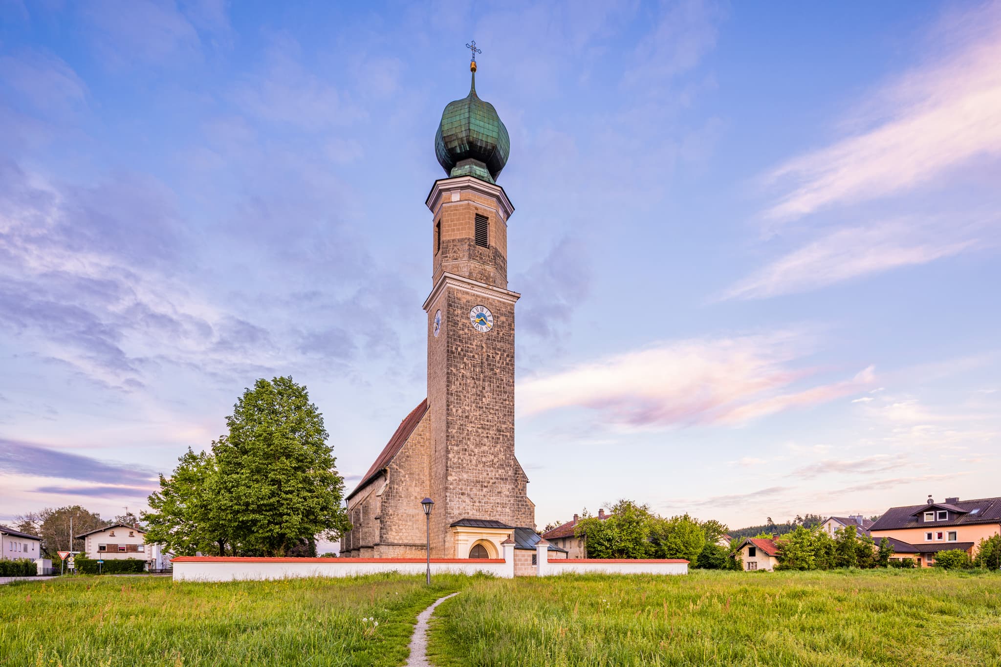 Pfarrkirche St. Rupertus in Burgkirchen am Wald, Tüßling, Altötting, Oberbayern, Deutschland. Kirche, Turm, Friedhof im Abendlicht.