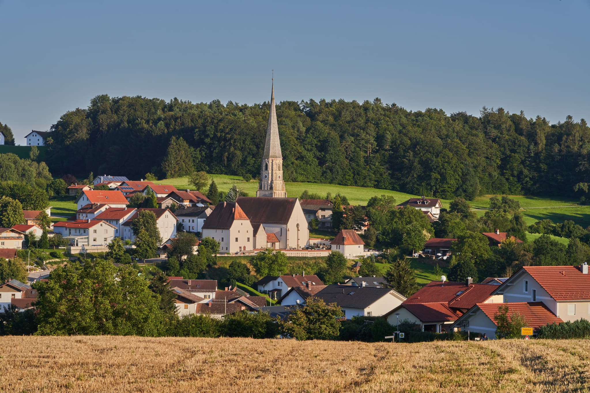 Idyllische Ortsansicht von Taubenbach in Reut, Landkreis Passau, Niederbayern, Deutschland. Wunderschöne Aussicht auf die Kirche und die umliegende Landschaft
