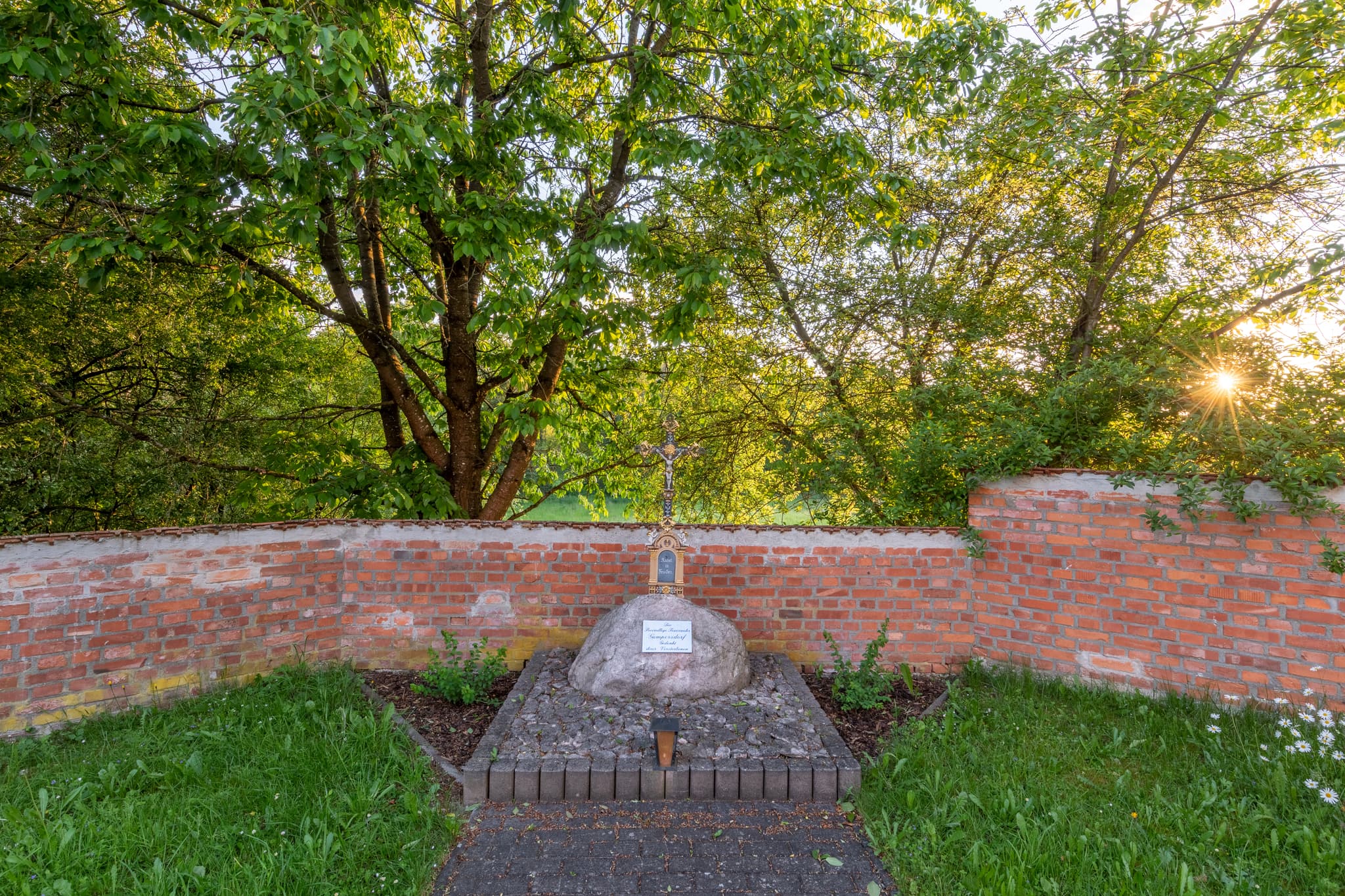 Filialkirche St. Rupert in Gumpersdorf, Zeilarn, Landkreis Rottal-Inn, Niederbayern, Deutschland. Sakralbau im Holzland, Mauer und Bäume, bei Abendsonne.