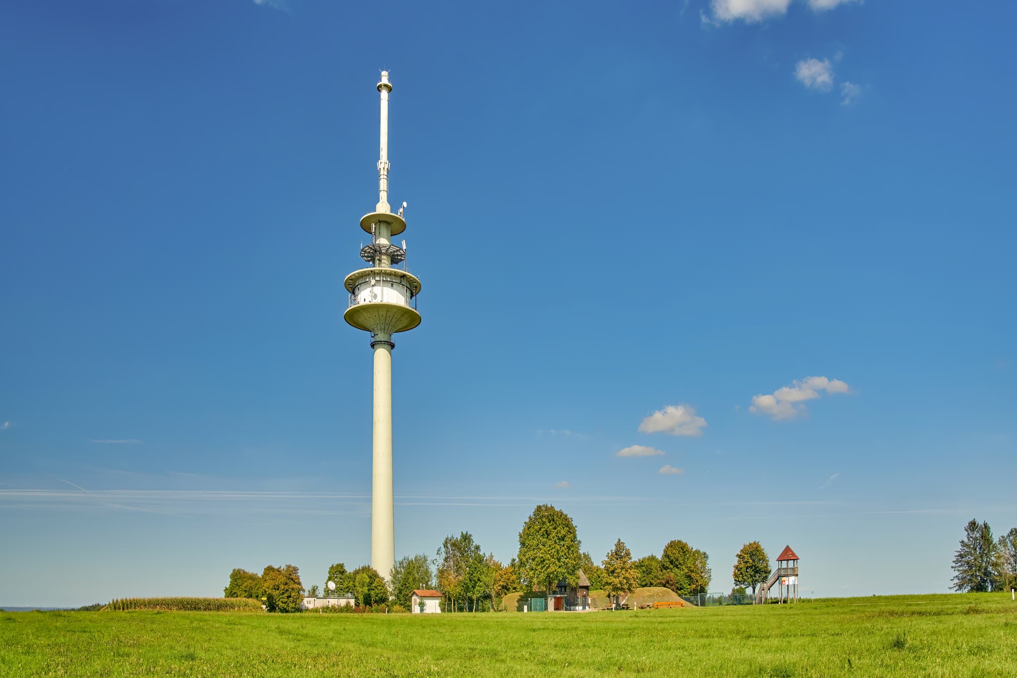 Funkturm auf grünen Wiesen in Schnaitsee, Gemeinde im Landkreis Traunstein, Oberbayern, Deutschland. Prägende Landschaft des Chiemgaus umgibt das Bauwerk.