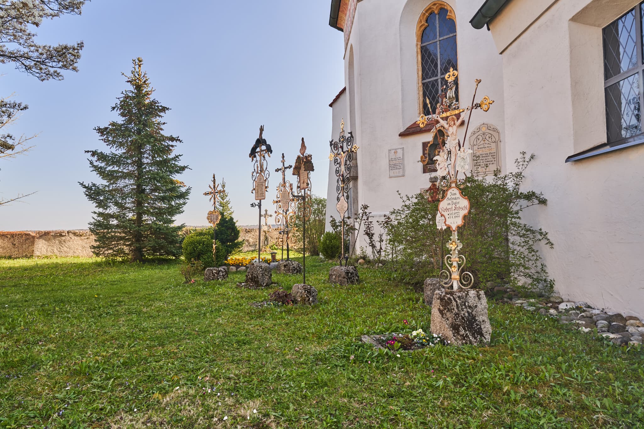 Friedhof in Perach, Kircheim Landkreis Altötting, Oberbayern, Inn-Salzach. Der Garten der Kirche mit kunstvollen Grabkreuzen. Regionale Sehenswürdigkeit.