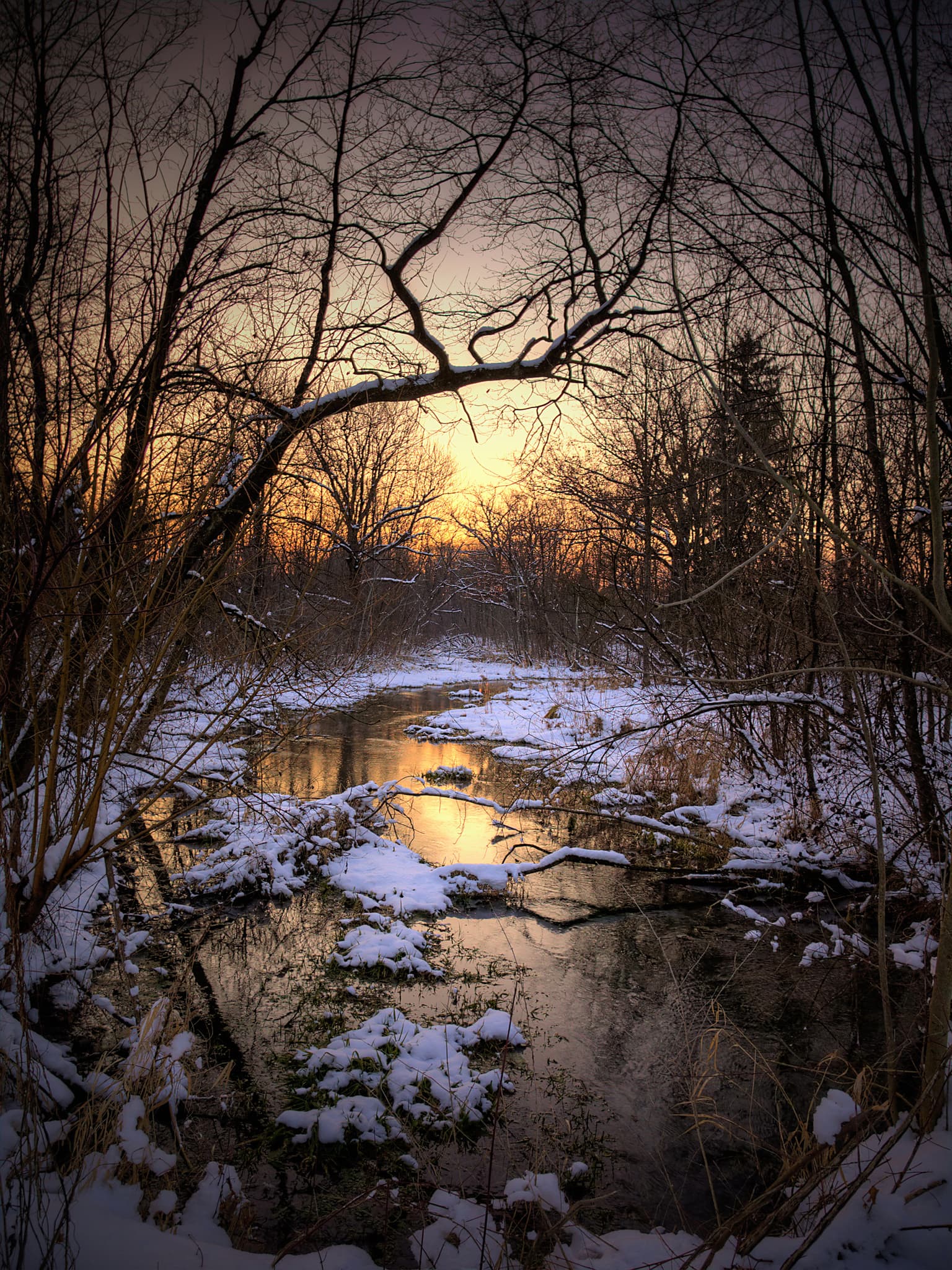 Bezaubernde Winterlandschaft am Haiming, Landkreis Altötting. Schneebedeckte Natur, stille Bäche und der goldene Sonnenuntergang bieten ein magisches Erlebnis.