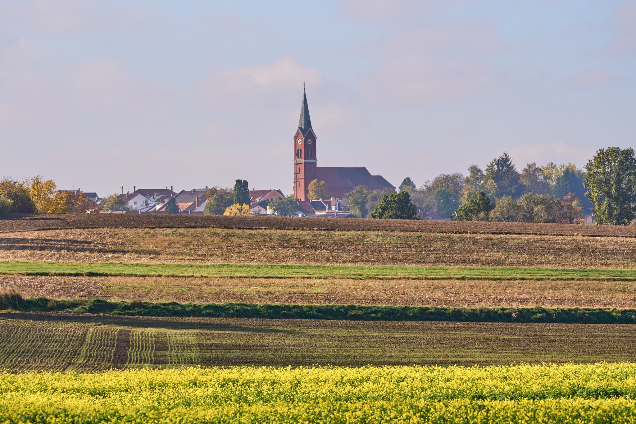 Ländliche Ortsansicht von Wurmannsquick, Rottal-Inn, Niederbayern, Deutschland. Zeigt die Pfarrkirche St. Andreas und Häuser mit Feldern im Holzland.