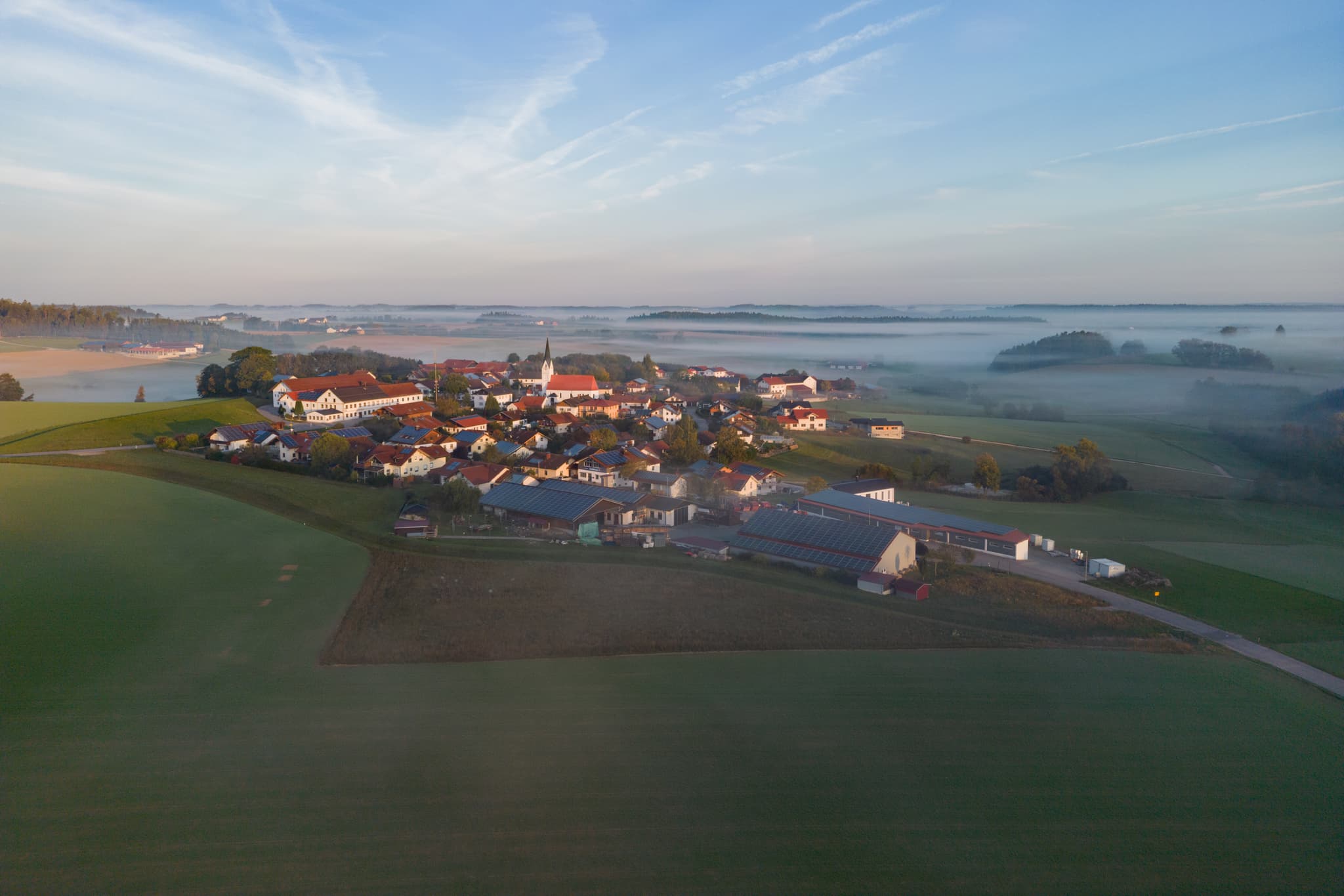 Luftbild von Arbing bei Reischach. Die Landschaft in Altötting, Oberbayern, Region Inn-Salzach, Deutschland, zeigt Felder und Nebel zum Herbstanfang.