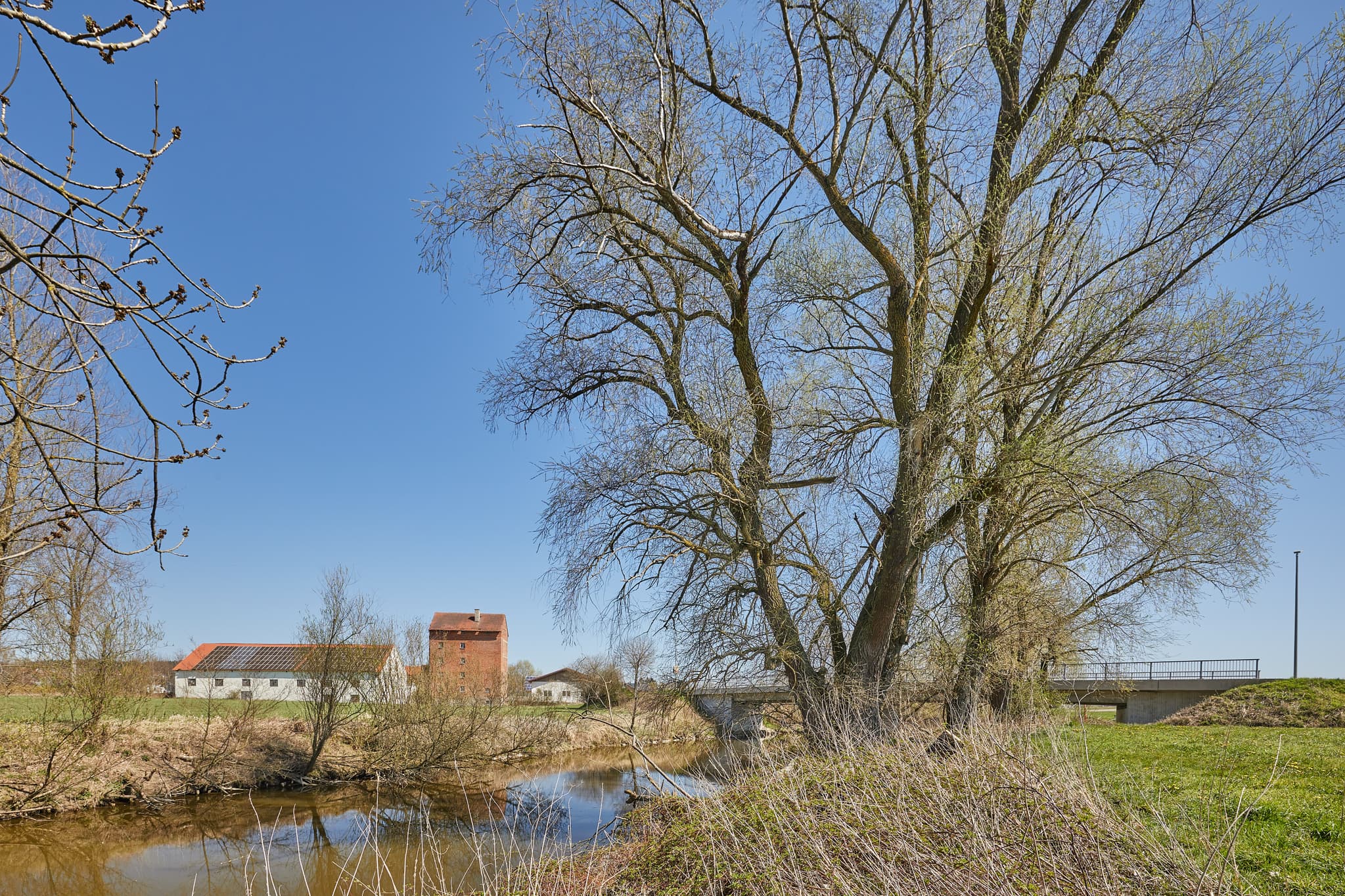 Ländliche Landschaft von Ort Rott Mühle, Unterdietfurt, Rottal-Inn, Niederbayern, Holzland, Deutschland. Zeigt Fluss, Bäume, Gebäude und Brücke.