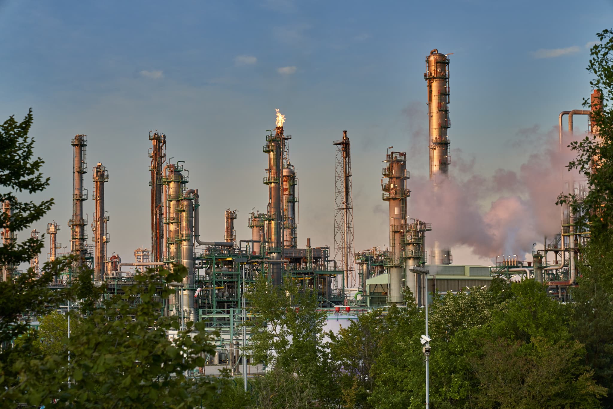 Industrieanlage mit Fackelbetrieb und Rauch in Burghausen, Landkreis Altötting, Oberbayern, Deutschland. Ein Blick auf die OMV Raffinerie im Inn-Salzach-Gebiet.