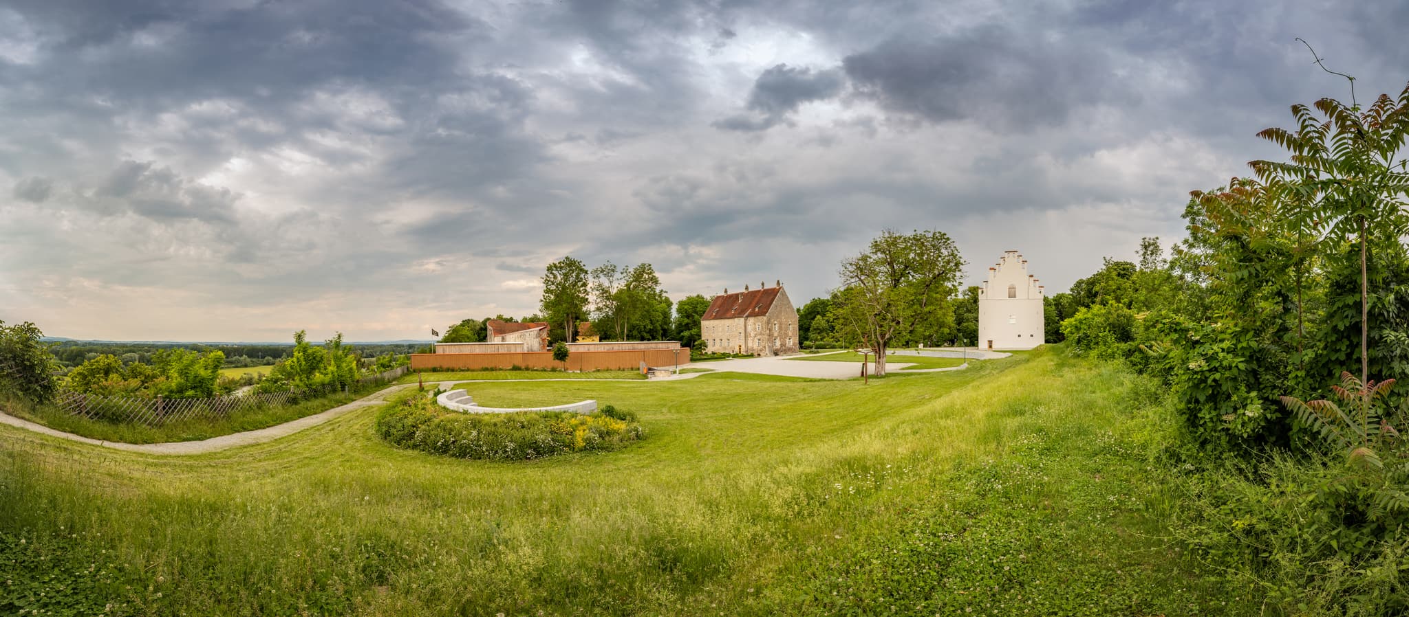 Burg Obernberg in Obernberg, Bezirk Ried, Oberösterreich, Österreich. Historisches Bauwerk auf Hügel. Grüne Landschaft, bewölkter Himmel.