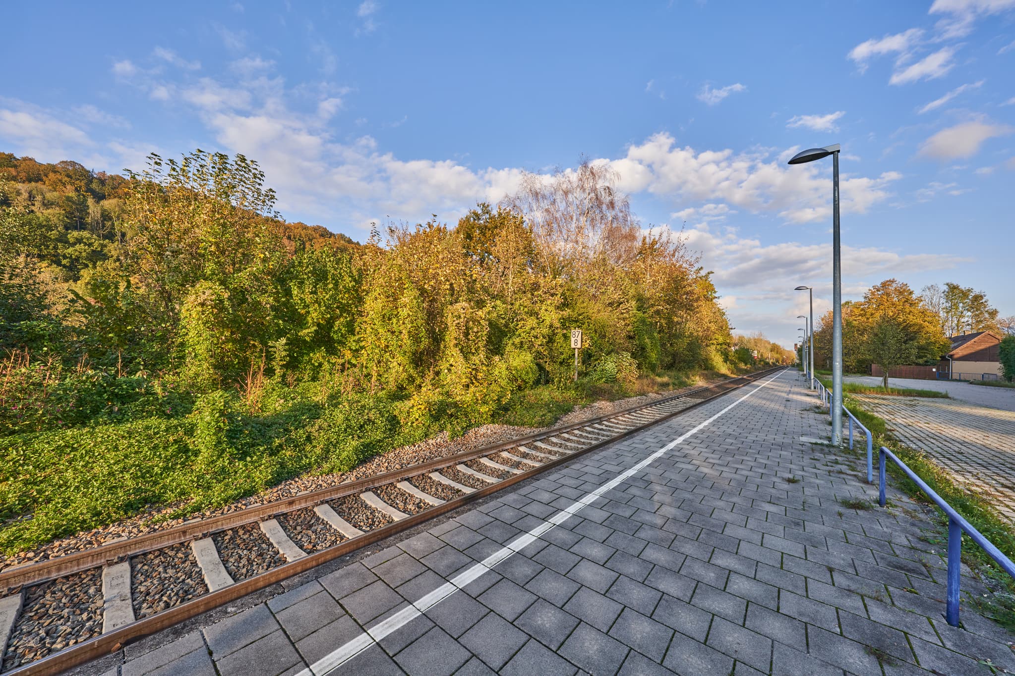 Bahnhof Eisenfelden in Winhöring, Landkreis Altötting, Oberbayern, Deutschland. Bahnsteig und Gleise umgeben von herbstlicher Natur der Inn-Salzach-Region.