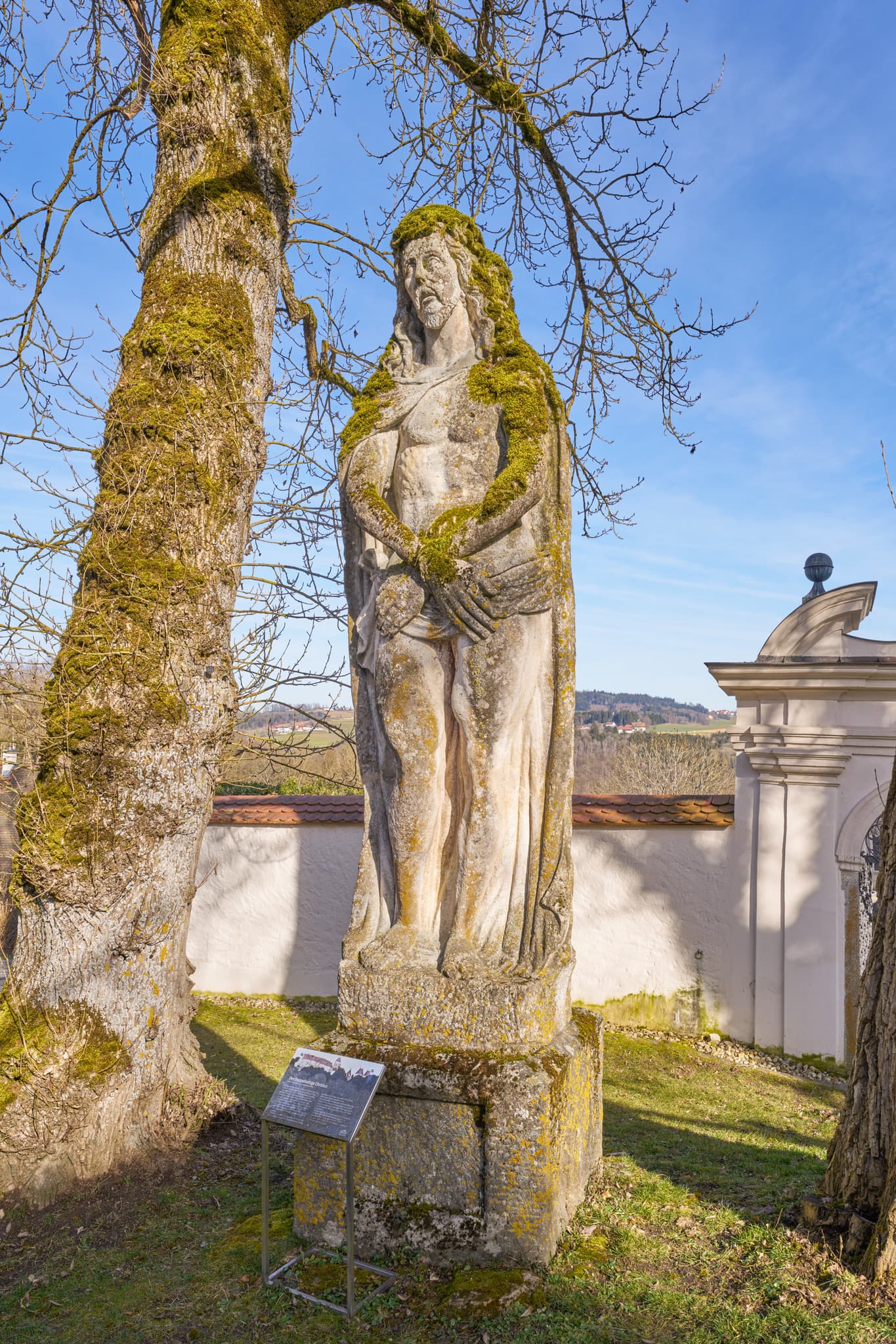 Moosbewachsene Statue am Schloss Neuburg bei Neuburg am Inn, im Landkreis Passau, Niederbayern. Darstellung des doppelseiten Christus in der Donau-Wald Region.
