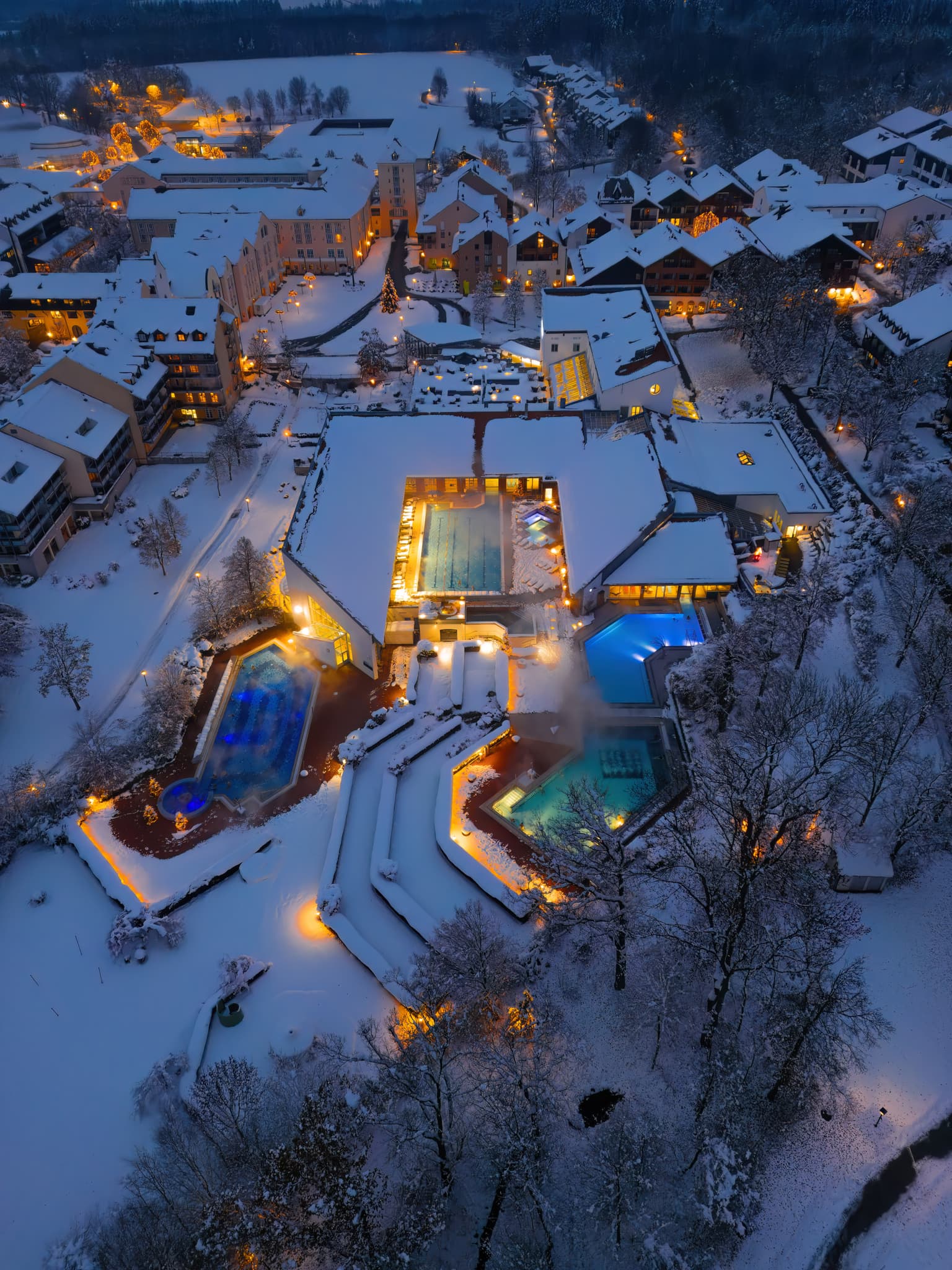 Nachtluftbild der Therme Bad Griesbach im Winter. Die Anlage ist schneebedeckt und beleuchtet. Bad Griesbach, Landkreis Passau, Niederbayern, Deutschland.