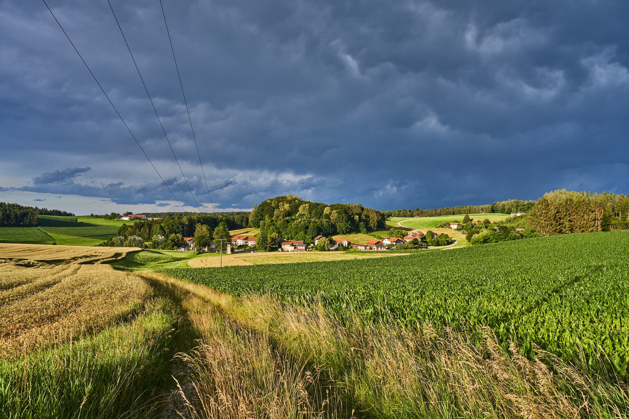 Landschaft mit Wolkenstimmung und weiten Felderen zeigt Waldberg, Reischach im Landkreis Altötting, Oberbayern, Deutschland.