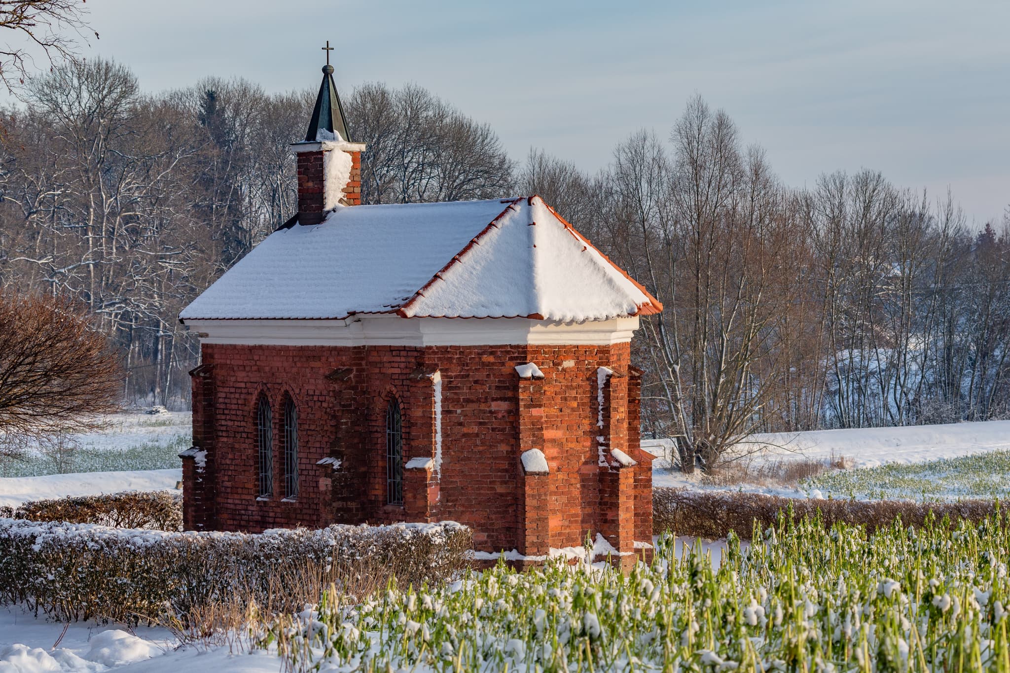 Winterliche Isen Kapelle in Winhöring, Landkreis Altötting, Oberbayern. Die Kapelle steht in der verschneiten Landschaft der Region Inn-Salzach, Deutschland.