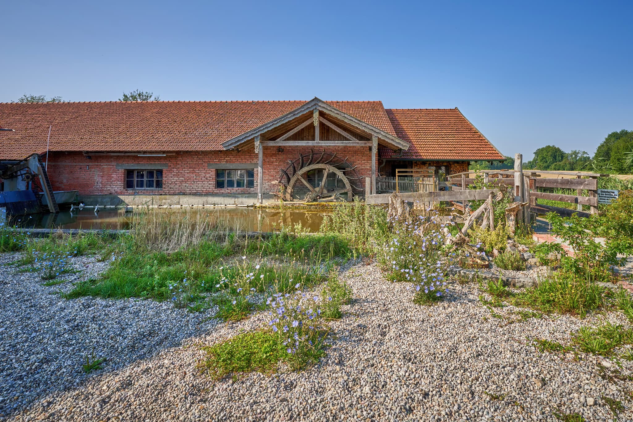 Historisches Wasserrad der Maumühle in Erharting, Landkreis Mühldorf am Inn, Oberbayern. Eine malerische Ansicht der Inn-Salzach Region in Deutschland.