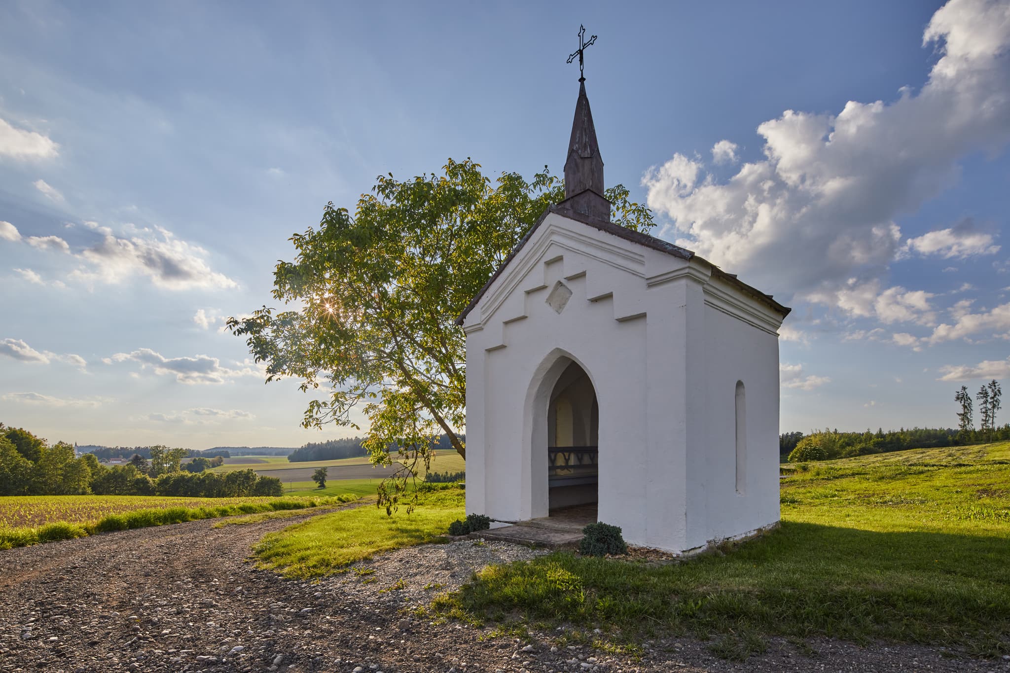 Bild einer kleinen Kapelle in Albersberg, Gemeinde Pleiskirchen, Altötting, Oberbayern, Holzland, Bayern, Deutschland. Kapelle ländlicher Umgebung mit Feldern.