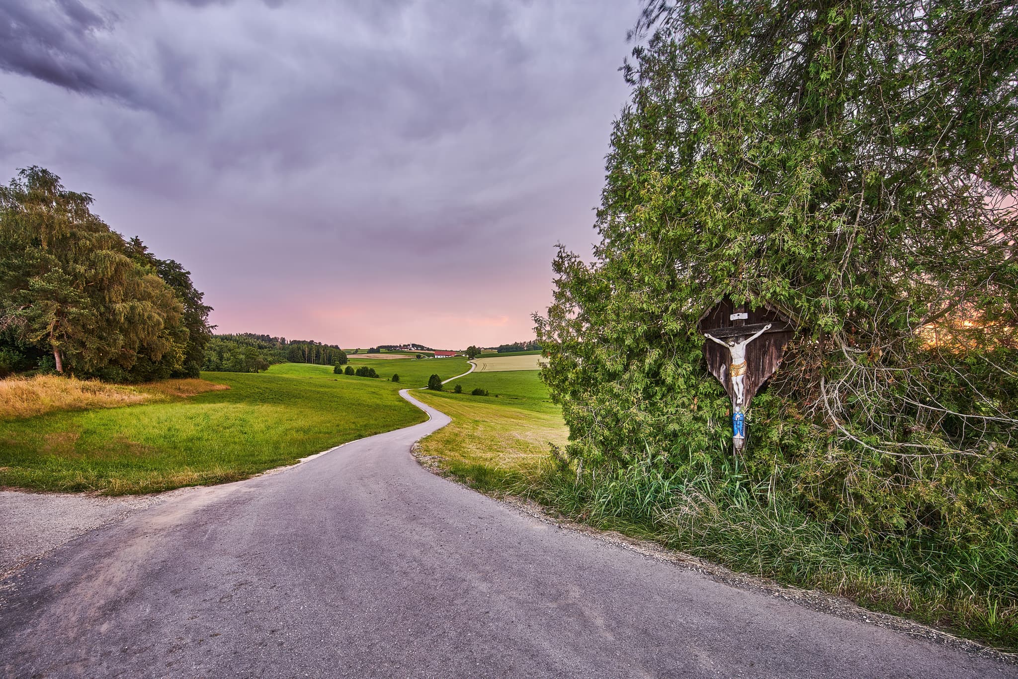 Bild eines Wegkreuzes an einem Feldweg bei Arbing in Reischach, Altötting, Oberbayern. Die ländliche Landschaft der Inn-Salzach Region in Deutschland.