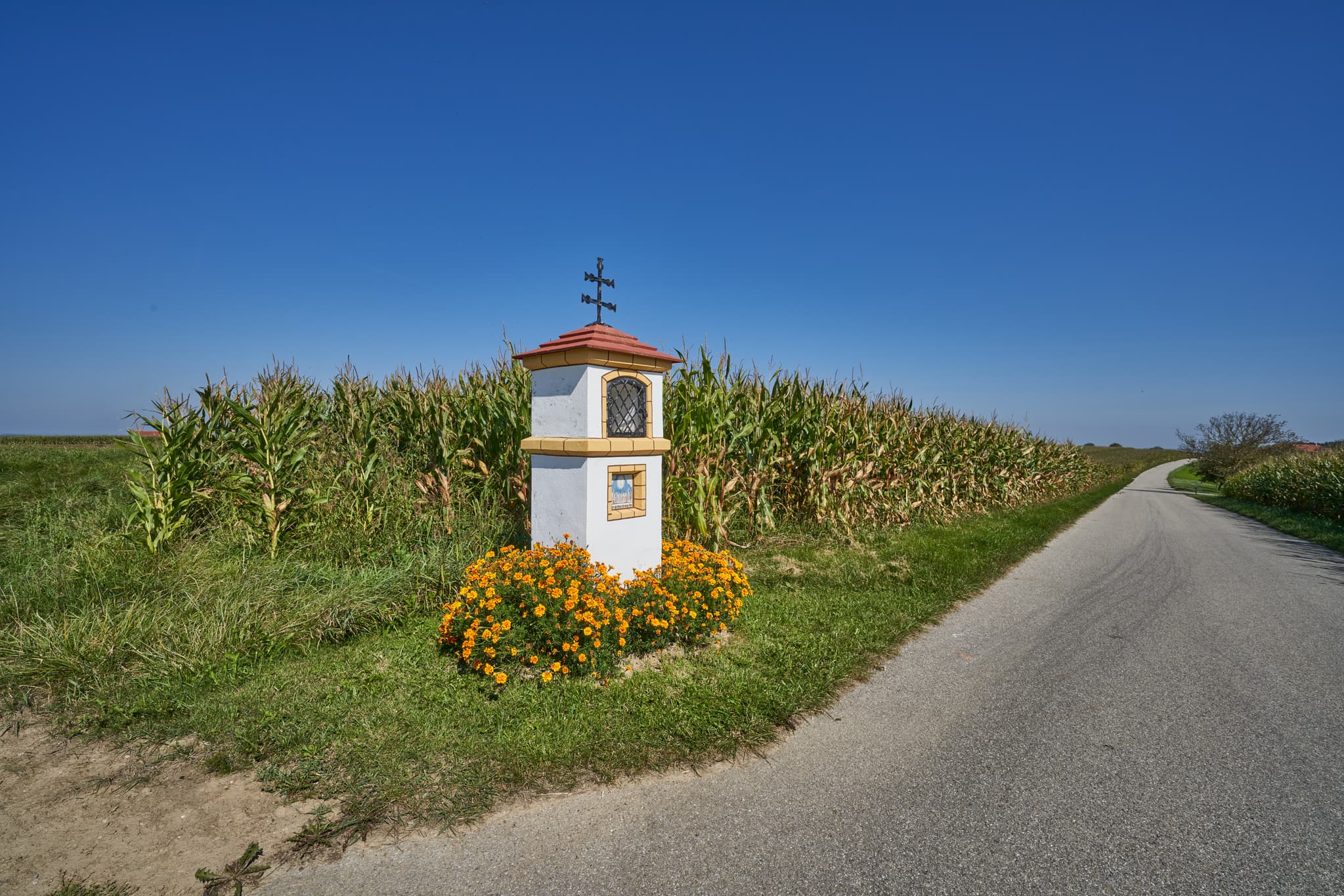 Bildstock am Wegrand, umgeben von Feldern bei Ofner, Oberschroffen, Unterneukirchen, Landkreis Altötting, Oberbayern, Inn-Salzach, Deutschland.