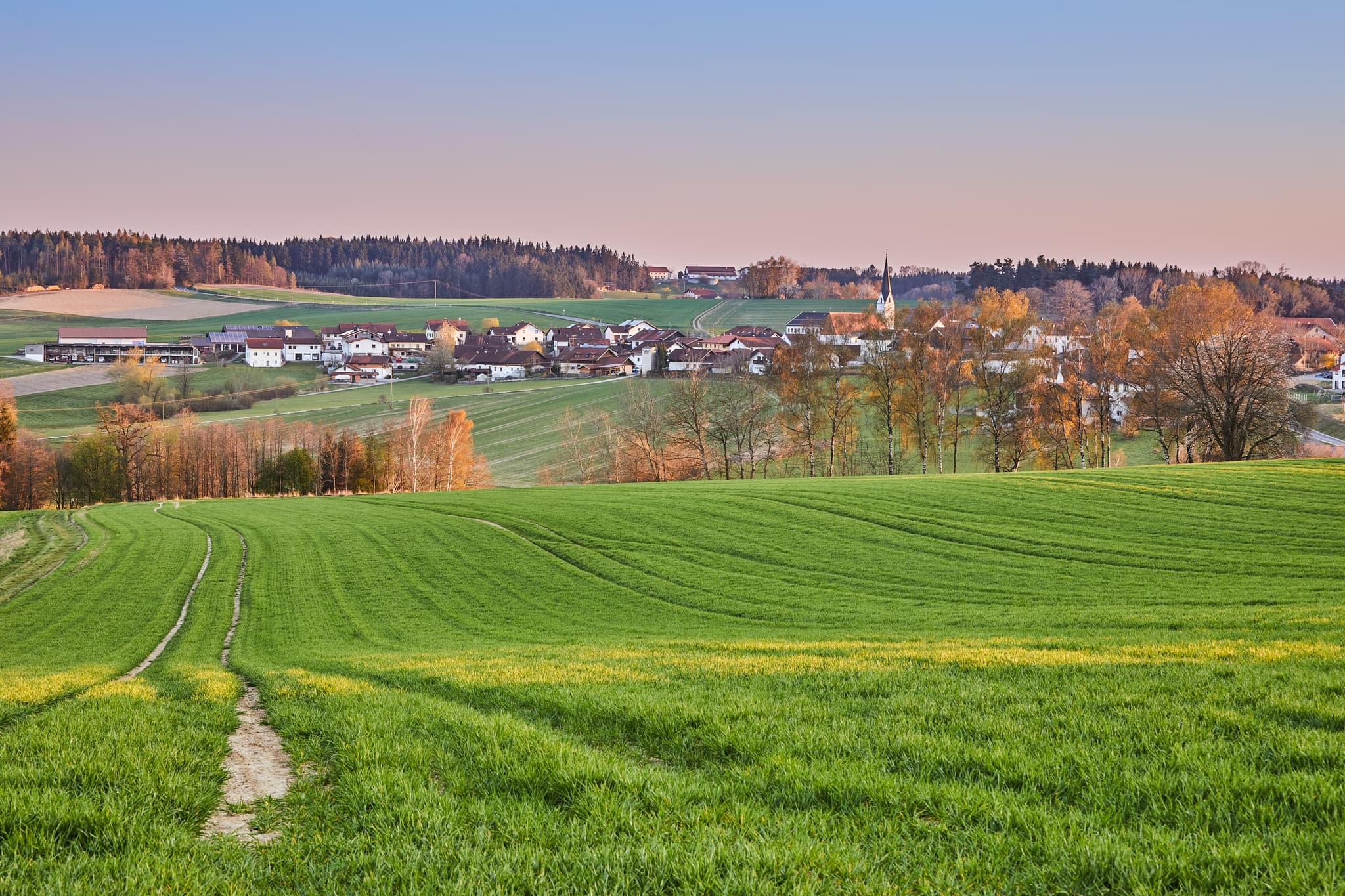 Aussicht über weite grüne Felder auf das Dorf Arbing bei Reischach, gelegen im Landkreis Altötting, Oberbayern, Deutschland. Idylle der Region Inn-Salzach.