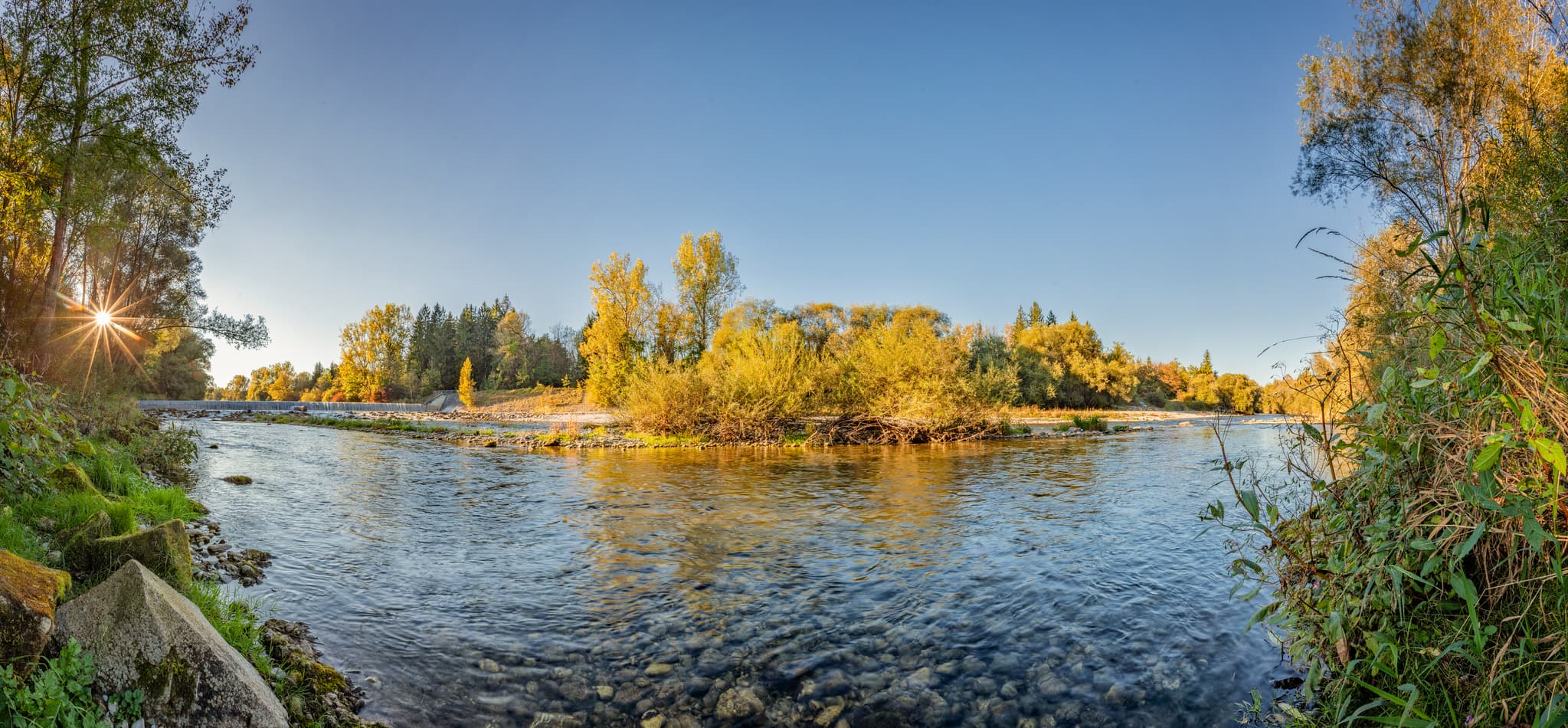Der untere Wasserfall der Alz in Garching, Altötting, Oberbayern, Deutschland. Klare Gewässer und herbstliche Ufer prägen die malerische Inn-Salzach-Region.