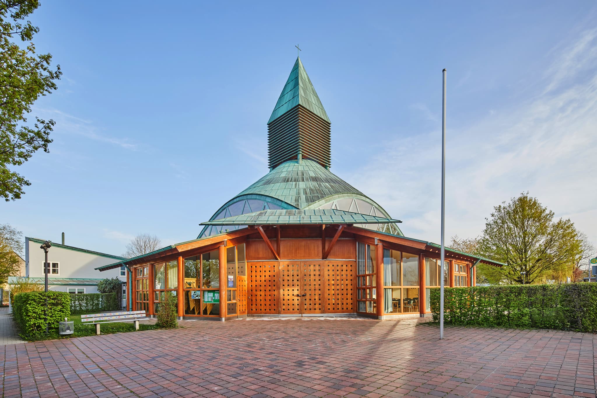 Moderne Evangelische Stadtkirche Altötting, Landkreis Altötting, Oberbayern, Deutschland. Markantes Kupferdach und Holzfassade prägen Gotteshaus.