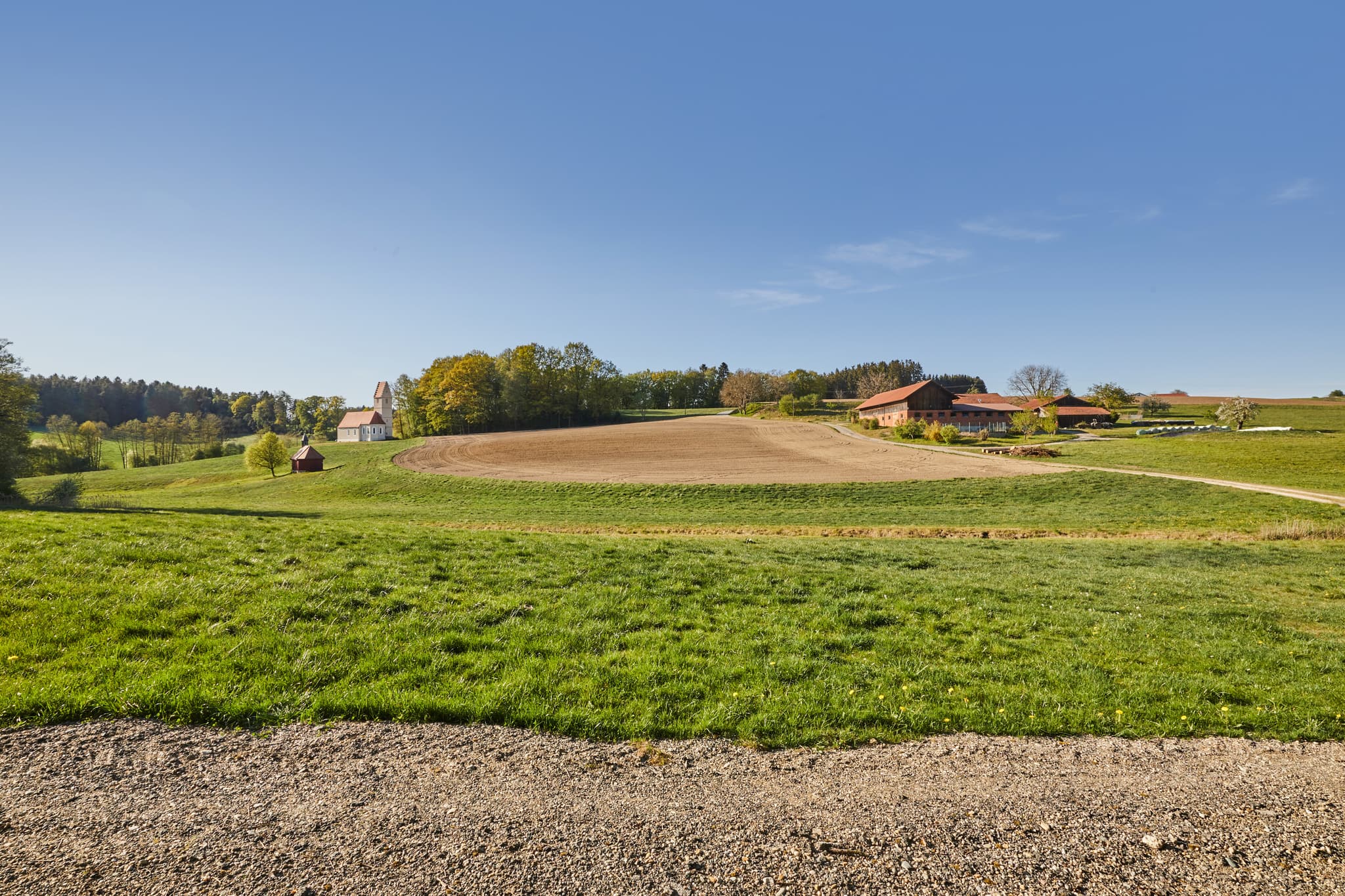 Landschaftliche Aufnahme von Feldern und Gebäuden in Sigrün, Pleiskirchen. Landkreis Altötting, Oberbayern, Inn-Salzach, Bayern, Deutschland.