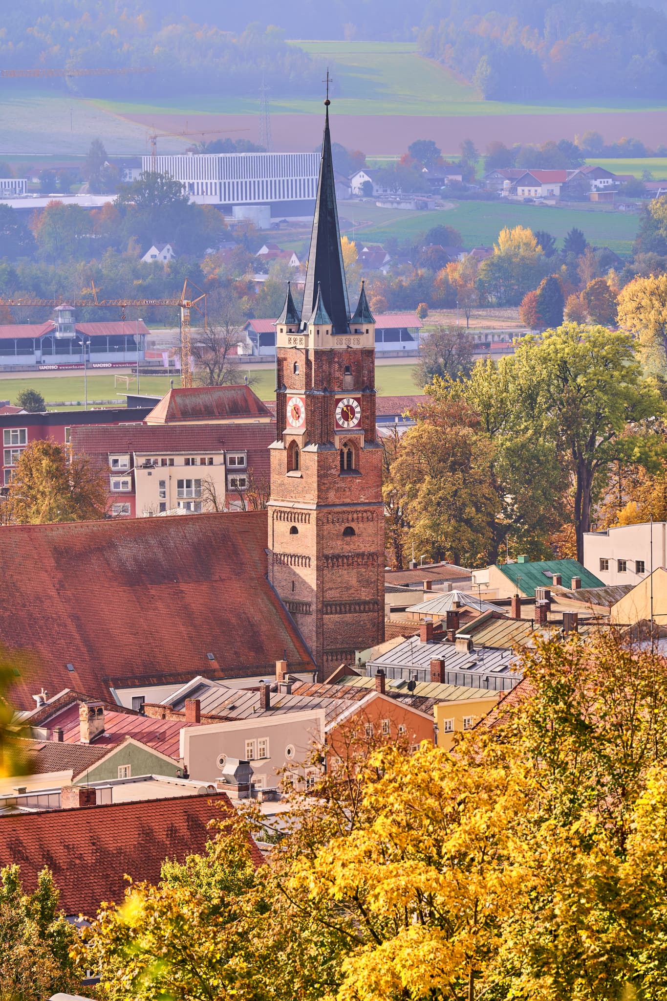 Blick auf die Stadt Pfarrkirchen vom Gartlberg aus, mit Kirche und Häusern. Die herbstliche Landschaft des Holzlands im Landkreis Rottal-Inn, Niederbayern
