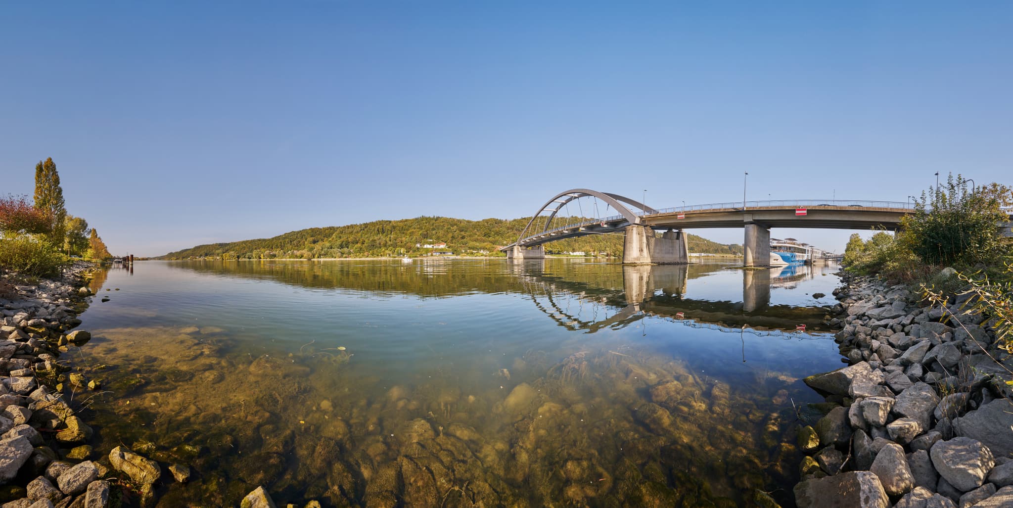 Panorama auf die Donau in Vilshofen mit Brücke und Schiff, umgeben von der Landschaft des Landkreises Passau, Niederbayern. Region Donau-Wald in Deutschland.