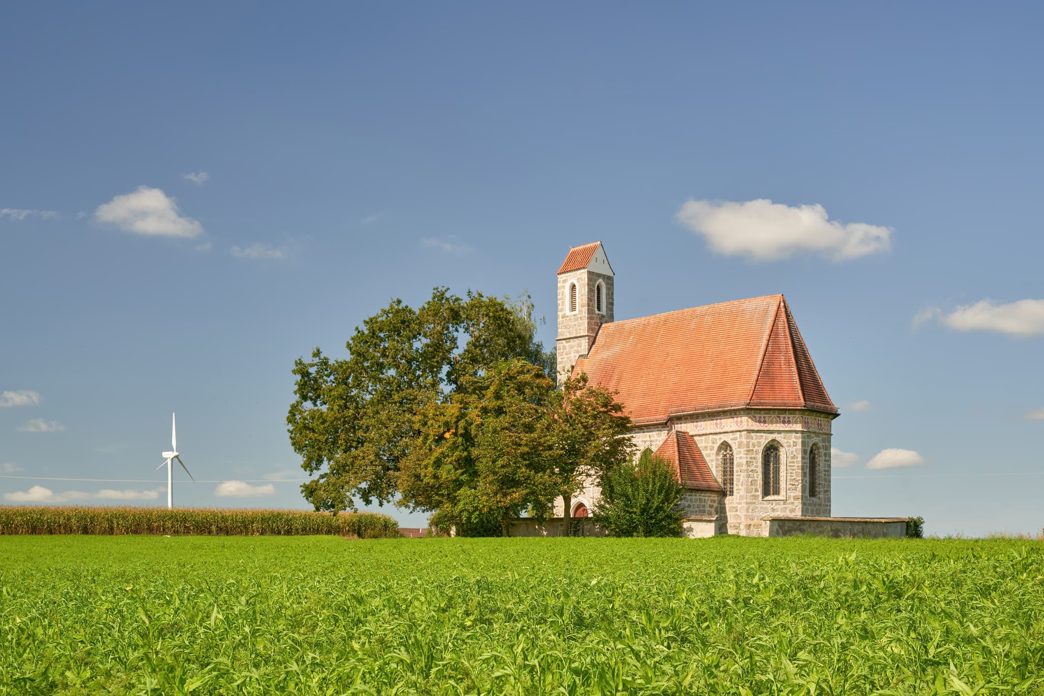Kirche St. Alban, Peterskirchen, Tacherting, Landkreis Traunstein, Oberbayern. Motiv der Kirche umgeben von Feldern im Chiemgau, Deutschland.