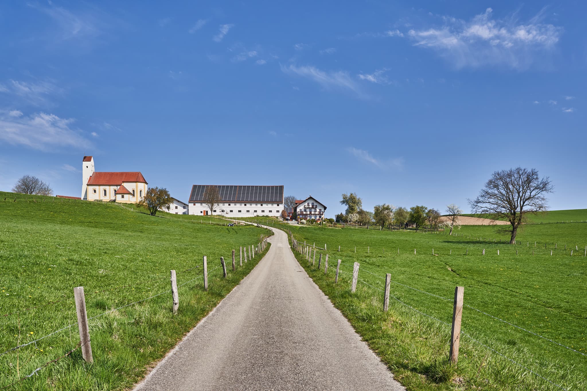 Idyllische Kirche Sankt Pankratius in Mettenheim, Mühldorf am Inn, Oberbayern, Region Inn-Salzach, Deutschland. Landschaftsbild mit Feldweg und Weitblick.