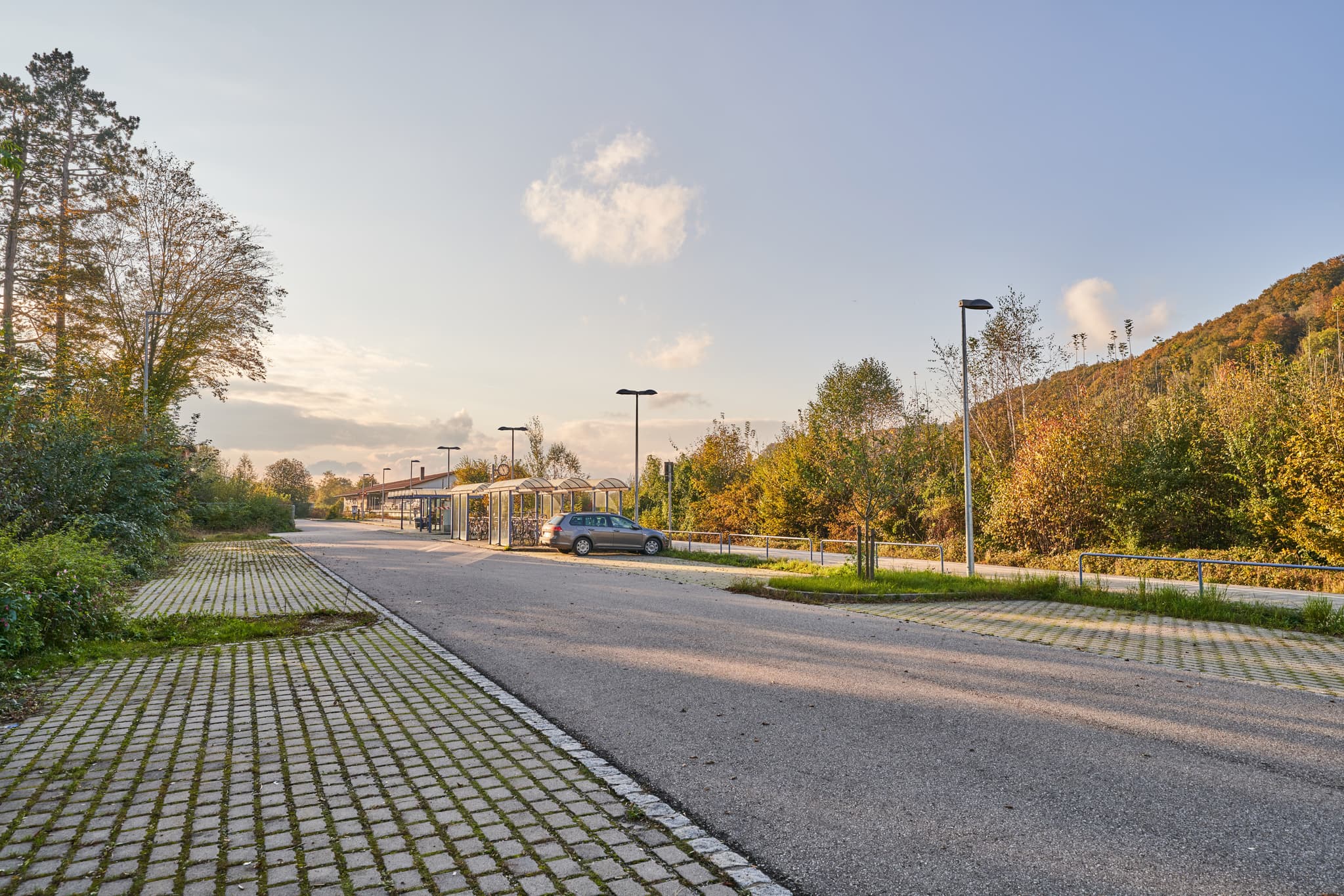 Parkplatz des Bahnhof Neuötting in Eisenfelden, Gemeinde Winhöring, Altötting. Bäume und Hügel im Inn-Salzach-Gebiet, Oberbayern, Deutschland.
