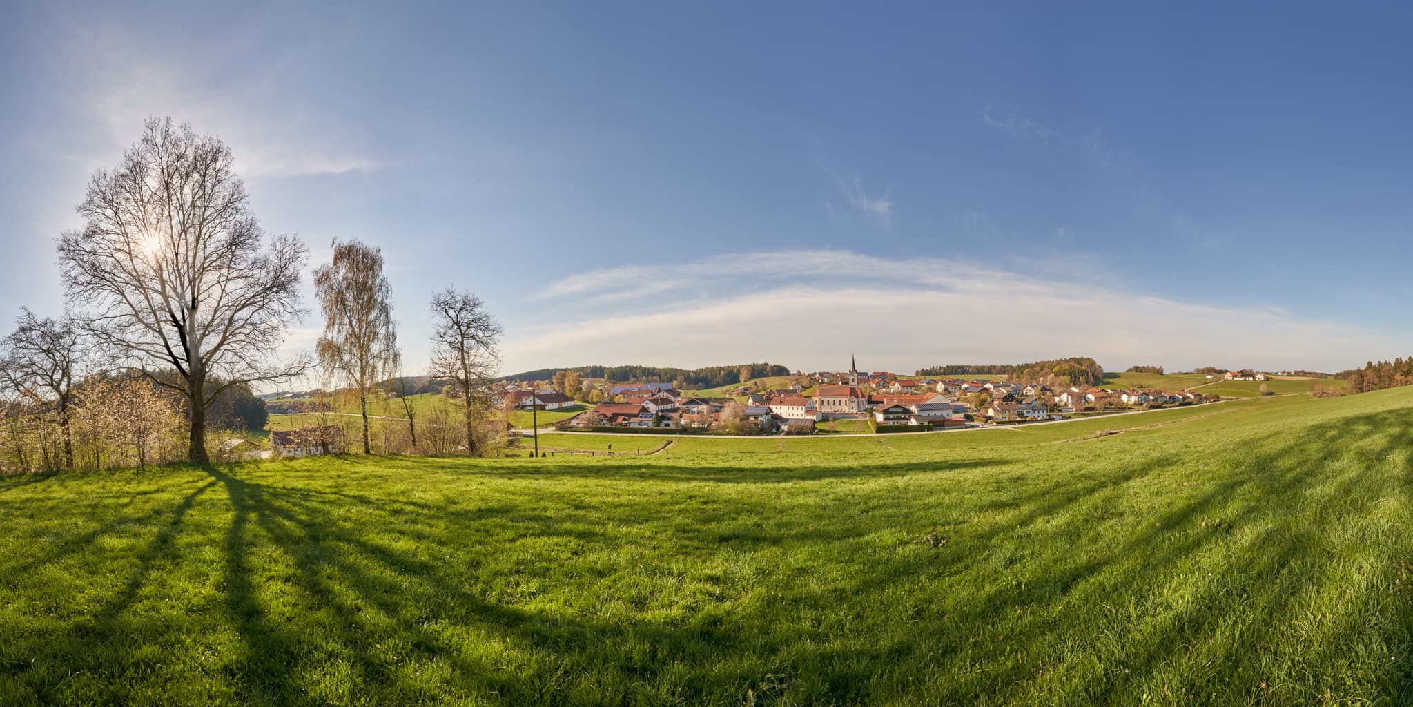 Weite Frühlingslandschaft bei Kreuzweg, Erlbach, Landkreis Altötting, Oberbayern, Inn-Salzach Region, Deutschland, mit Blick auf das Dorf und grüne Wiesen.