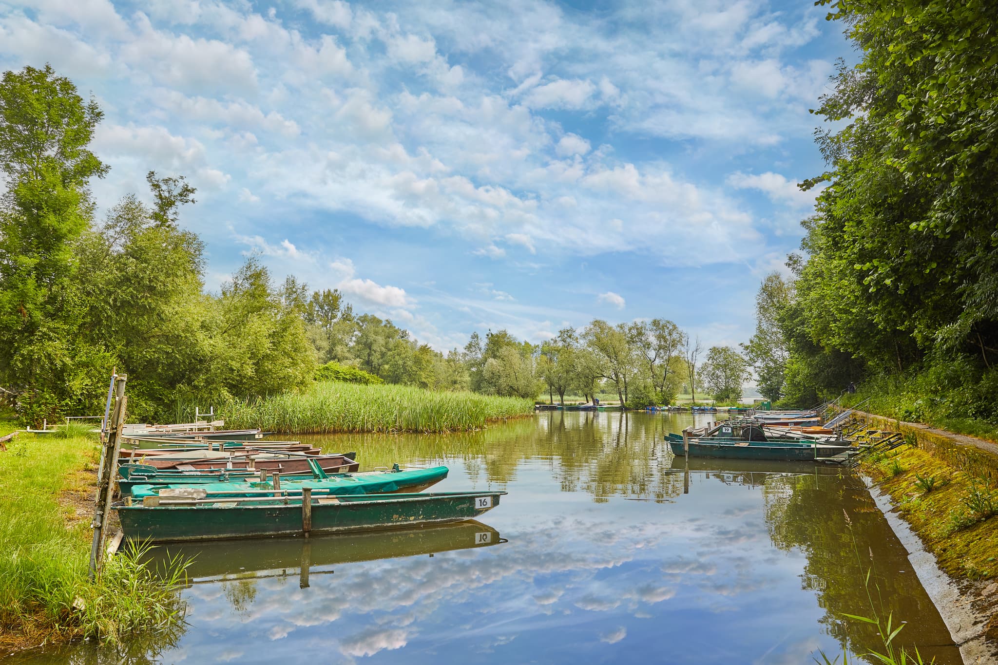 Hafenanlage Boote Wasser in Reichersberg, Oberösterreich. Idyllische Szene im Zentralraum Ried, Österreich, mit grünen Ufern unter blauem Himmel.
