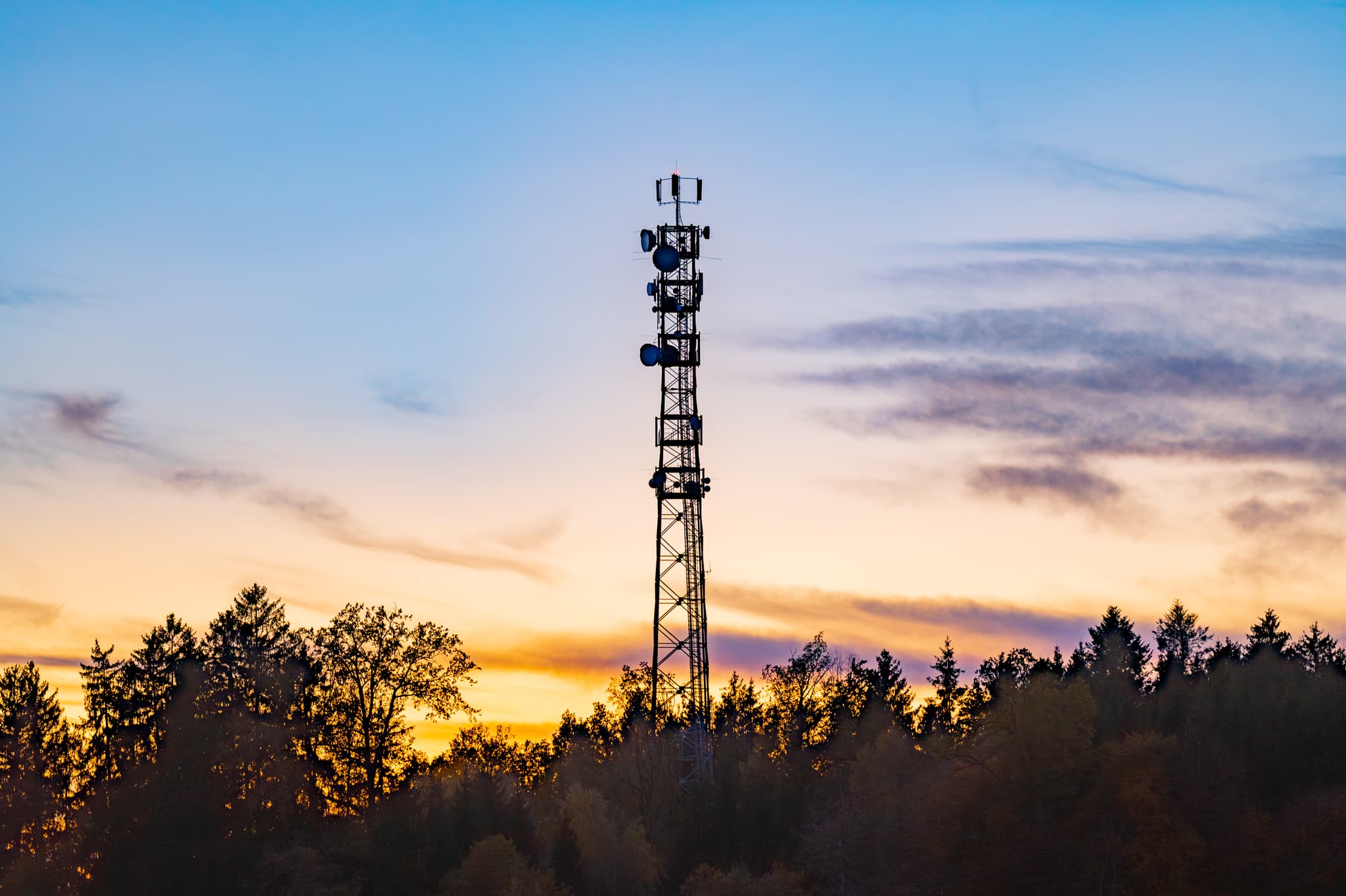 Funkturm im Abendhimmel in Rottenstuben, Hebertsfelden, Rottal-Inn, Niederbayern. Silhouette von Turm und Bäumen prägen die Landschaft im Holzland, Deutschland.