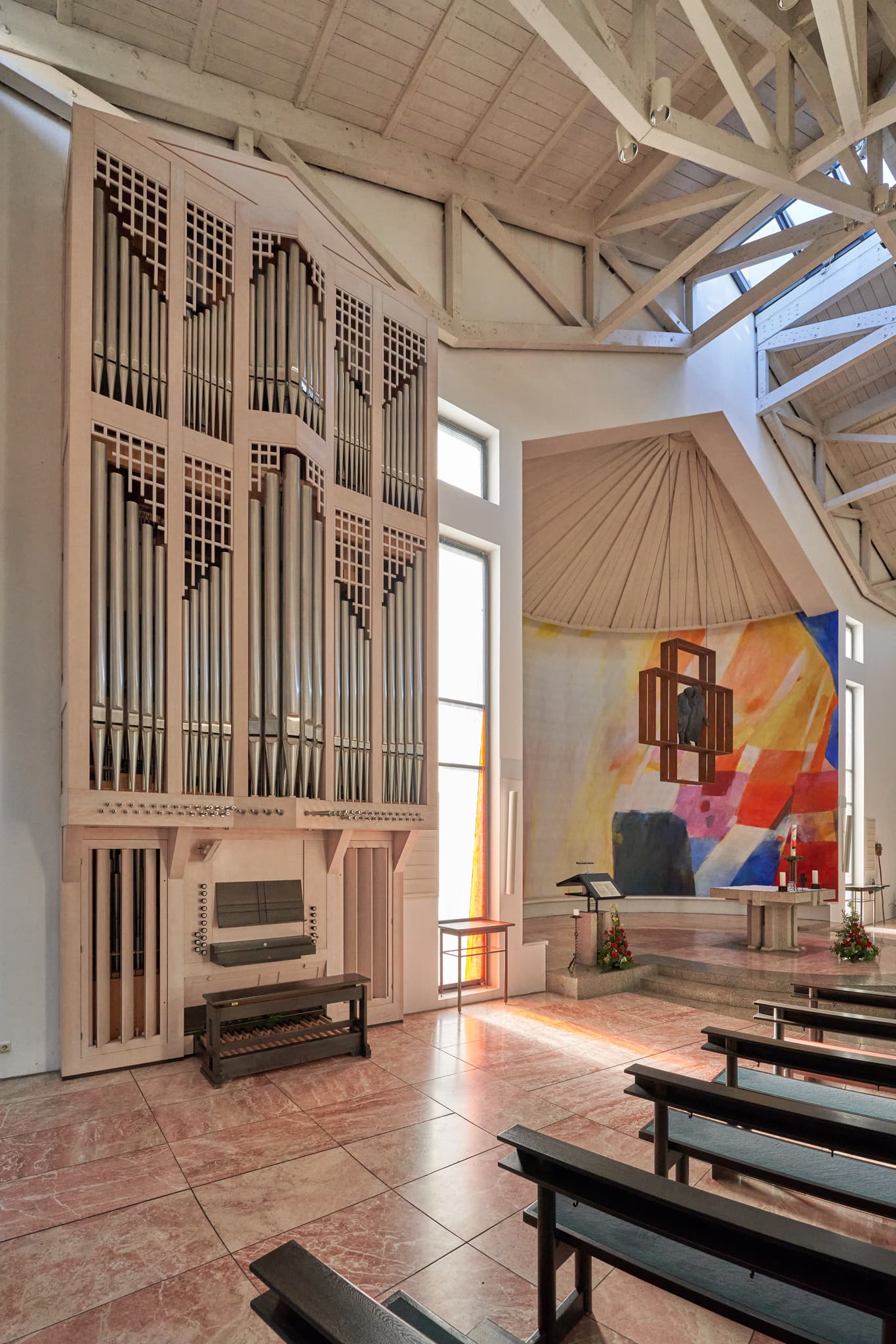 Innenansicht der modernen Emmauskirche in Bad Griesbach, Landkreis Passau. Eine beeindruckende Orgel und ein farbenfrohes Altarbild prägen diesen Sakralbau.