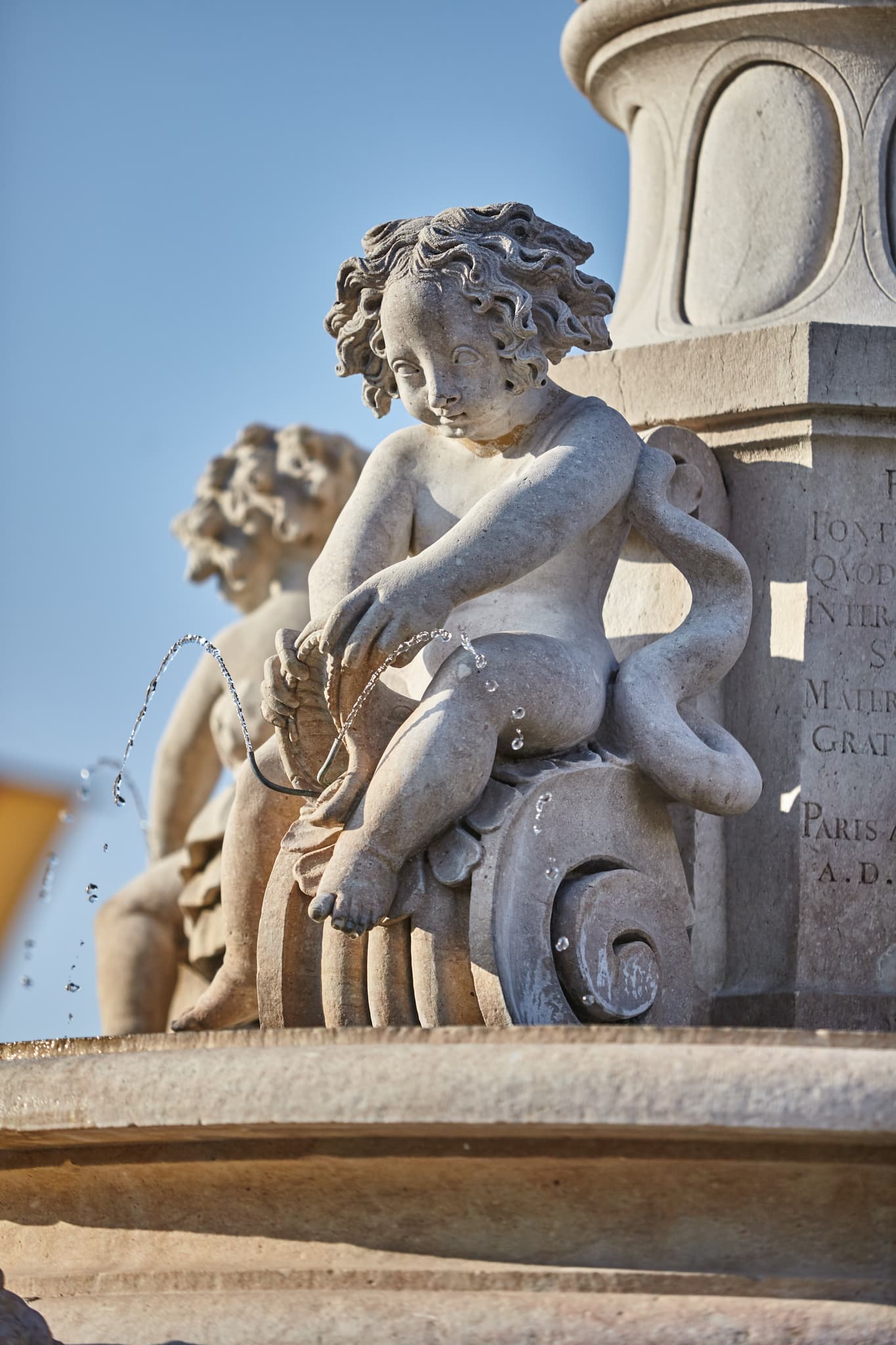 Marienbrunnen mit Puttenfiguren am Kapellplatz Brunnen in Altötting. Gelegen im Landkreis Altötting, Oberbayern, Region Inn-Salzach, Deutschland.