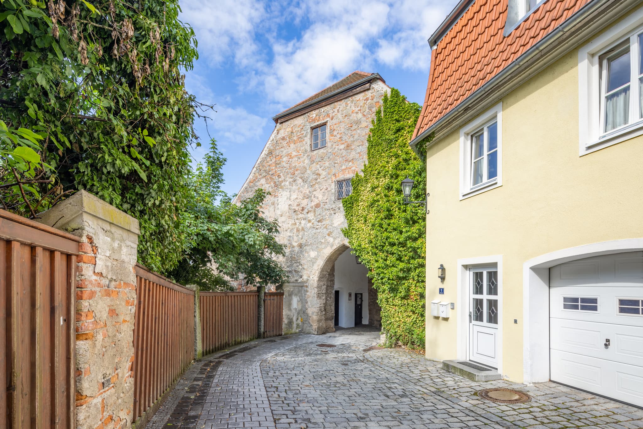 Fußweg am Heimatmuseum in Schärding, Linz, Oberösterreich. Gebäude und Torbogen prägen die Szene im Zentralraum Linz, Österreich.