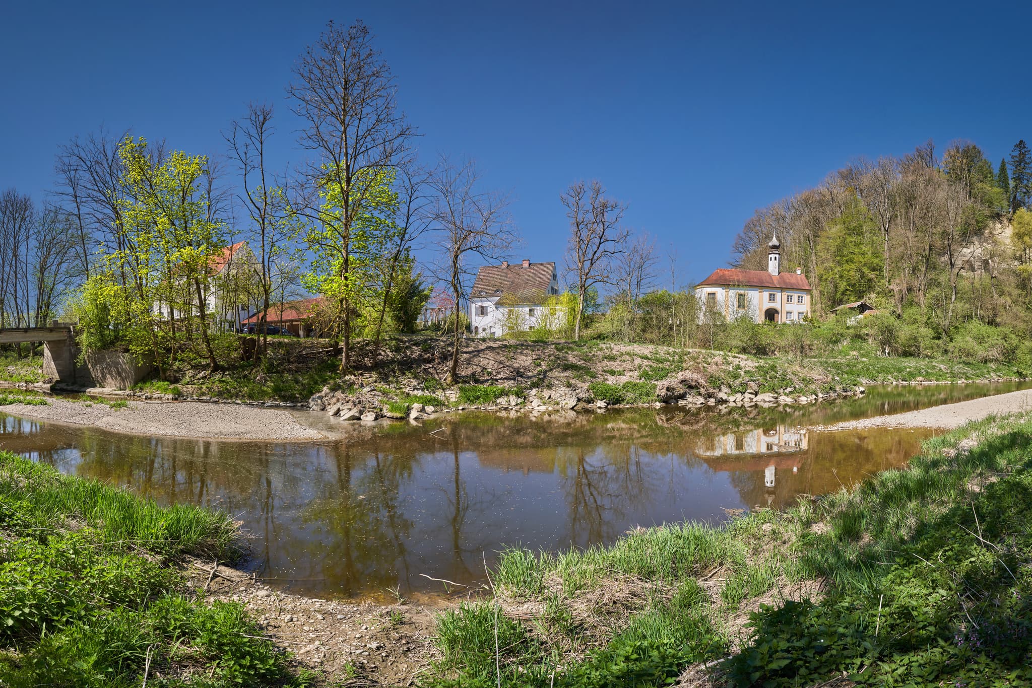 Die Alte Steinerne Brücke in Töging am Inn, Altötting. Historisches Motiv im bayerischen Oberbayern, Region Inn-Salzach, Deutschland. Flusslandschaft mit Brücke