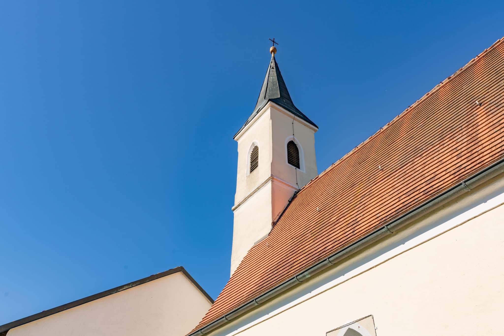 Wallfahrtskirche Mariä Himmelfahrt in Guteneck Johanniskirchen, Rottal-Inn, Niederbayern, Deutschland. Kirchturm und Dach vor blauem Himmel im Holzland.