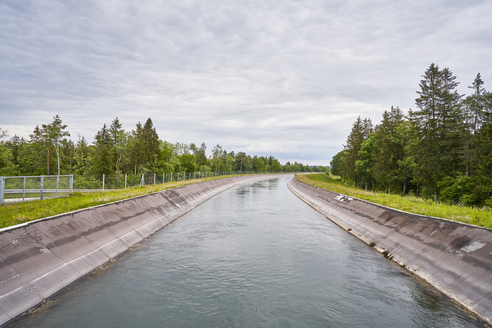 Der Alz Kanal in Gufflham, Burgkirchen, Altötting, Oberbayern. Eine betonierte Wasserstraße, gesäumt von Ufern und Bäumen, Region Inn-Salzach.