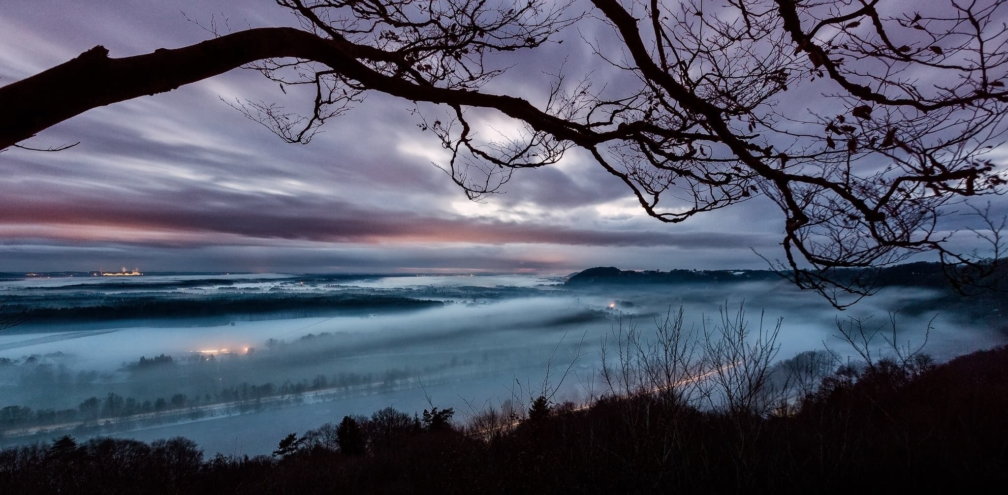 Winterlicher Ausblick von der Dachlwand, Marktlberg Gassen, Marktl, Landkreis Altötting, Inn-Salzach Region zeigt eine weite, neblige Landschaft bei Dämmerung.