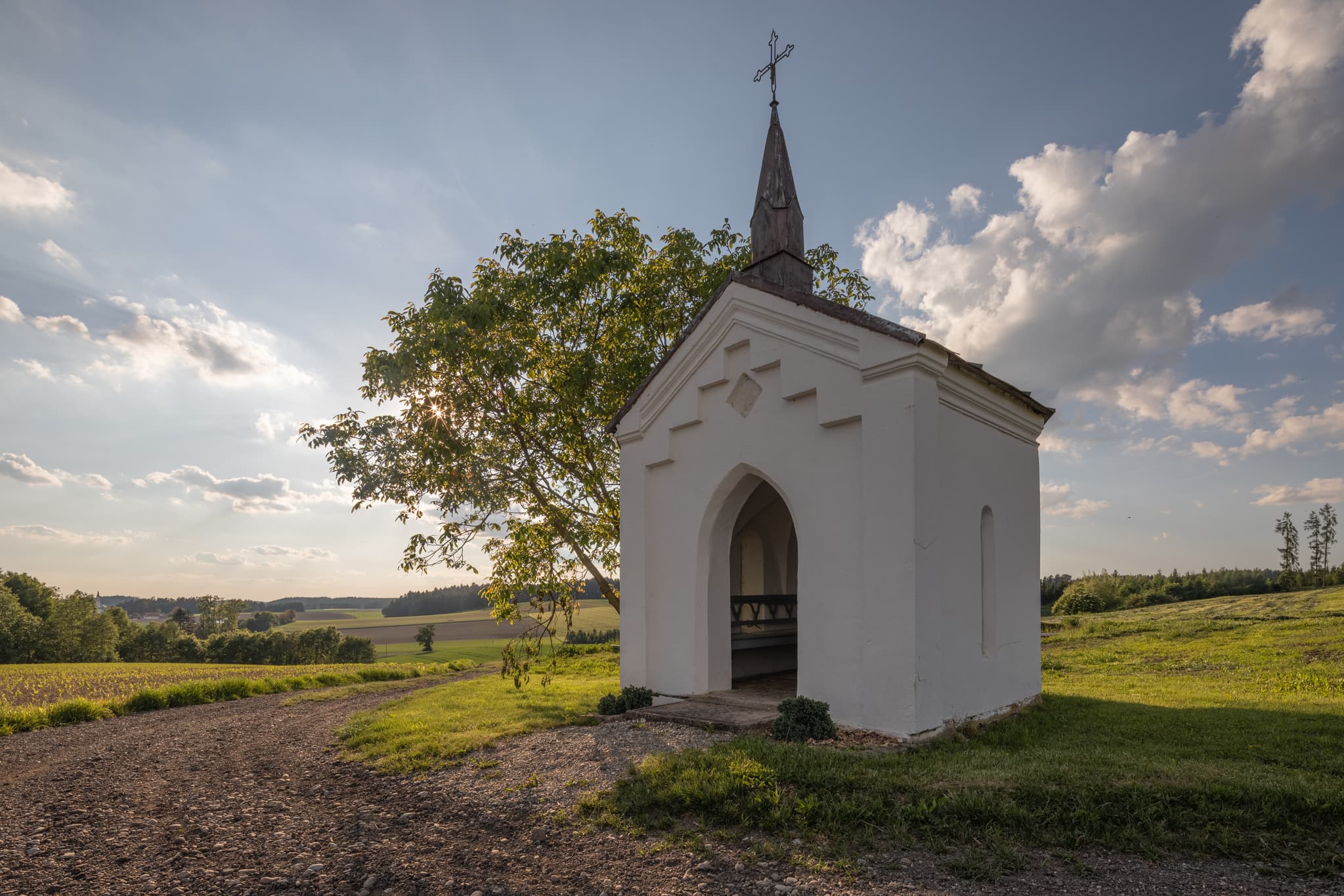 Bild einer kleinen Kapelle in Albersberg, Gemeinde Pleiskirchen, Altötting, Oberbayern, Holzland, Bayern, Deutschland. Kapelle ländlicher Umgebung mit Feldern.
